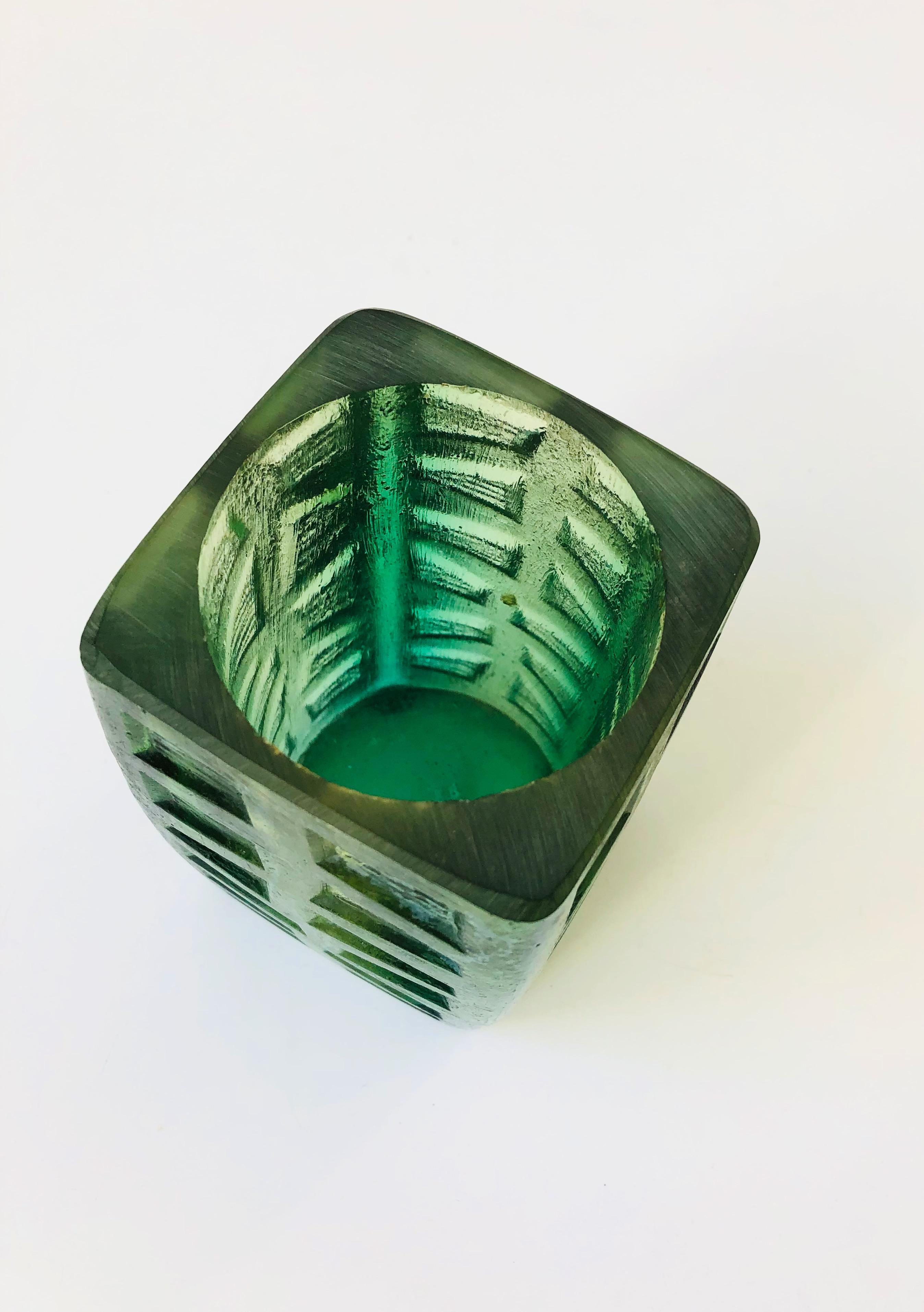 A mid-century vessel to use as a candle holder or vase. Made by Sascha Brastoff out of green textured resin. Signed on the base.
 