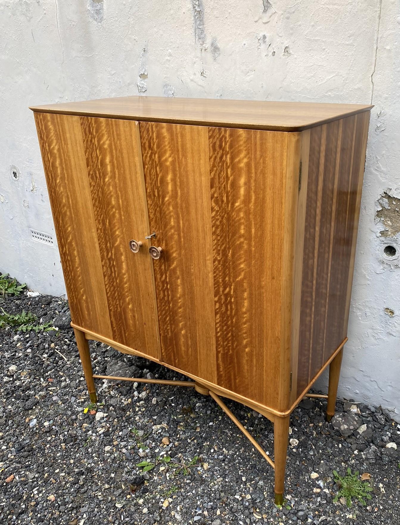 Mid-Century Satinwood Tallboy Cabinet for Heals, Utility Furniture, English, 1950s

Rare and beautiful mid-century tallboy made of satinwood and beech, with two turned knobs and an elegant stretcher, Turned legs with brass caps. This tallboy opens
