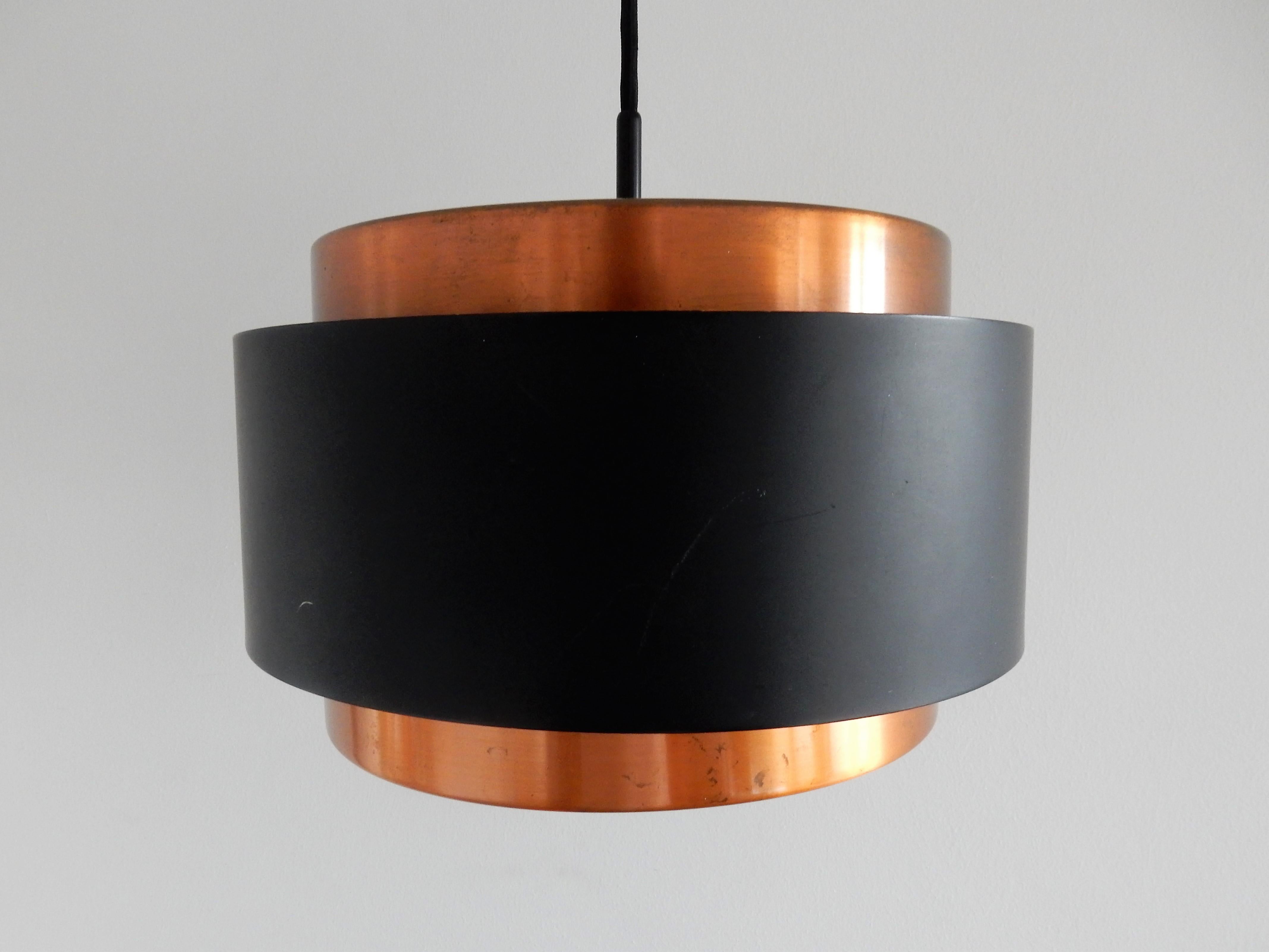 This Saturn pendant lamp is made of brass and black lacquered metal, combined with white plexiglass where the light shines through beautifully. The lamp is labelled inside by Fog & Mørup. It is in a very good condition with some smaller signs of age