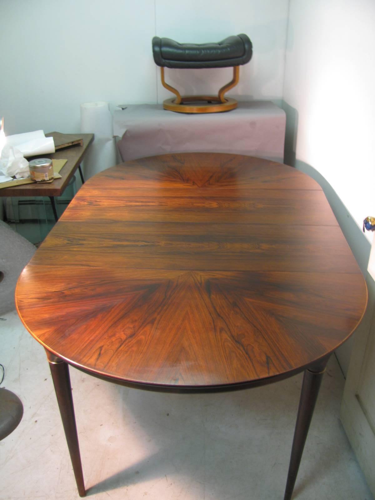 Round with inlay crouch rosewood design. Turned legs which are capped with solid brass rings. Table has two leaves which are 15.75 inches each. Table with both leaves in is 78.5 total.