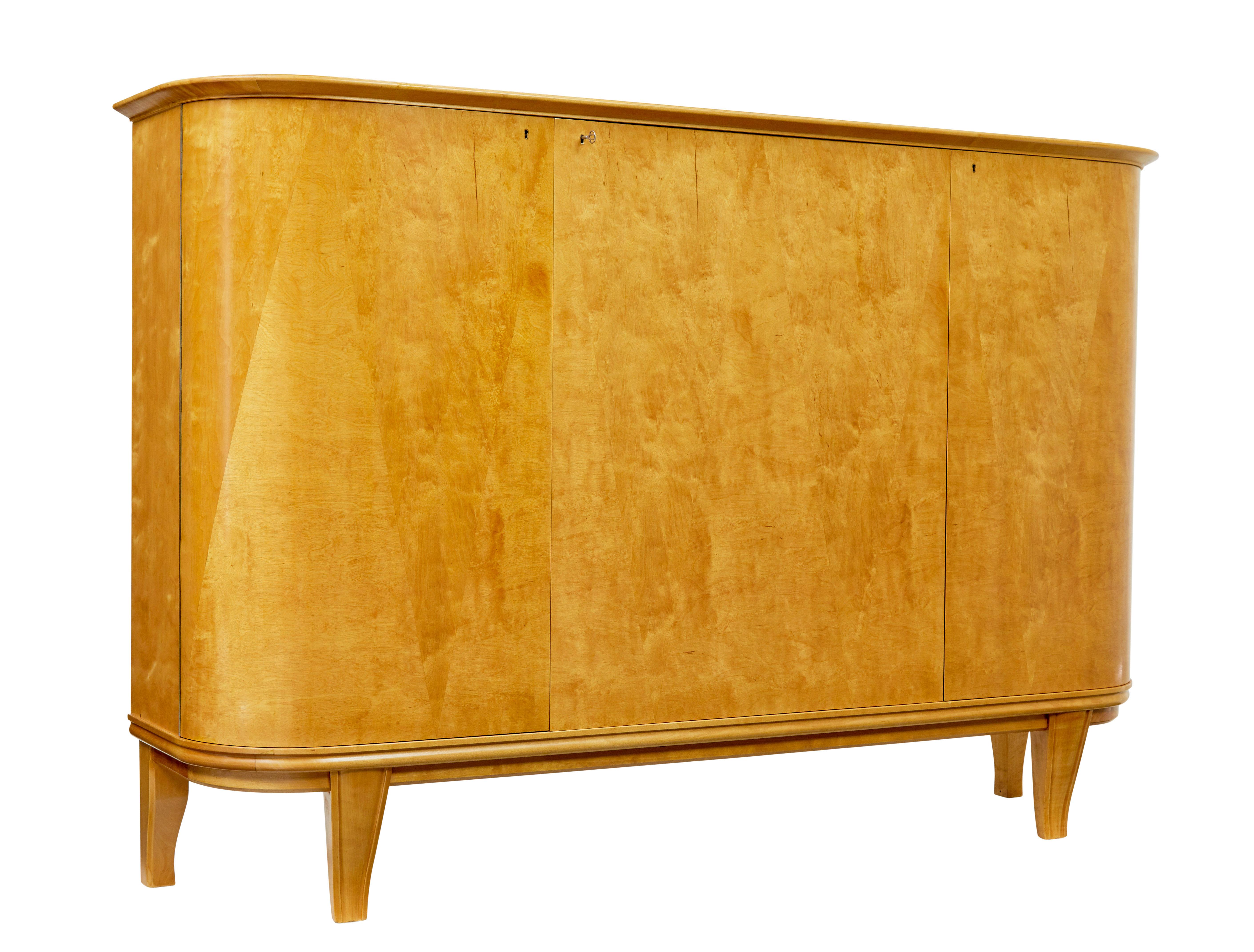 Mid century Scandinavian birch inlaid shaped sideboard circa 1950.

We are pleased to offer this fully refurbished piece of Swedish mid century design, in the form of this buffet/sideboard.

Inlaid with slight contrasting timbers in a triangular