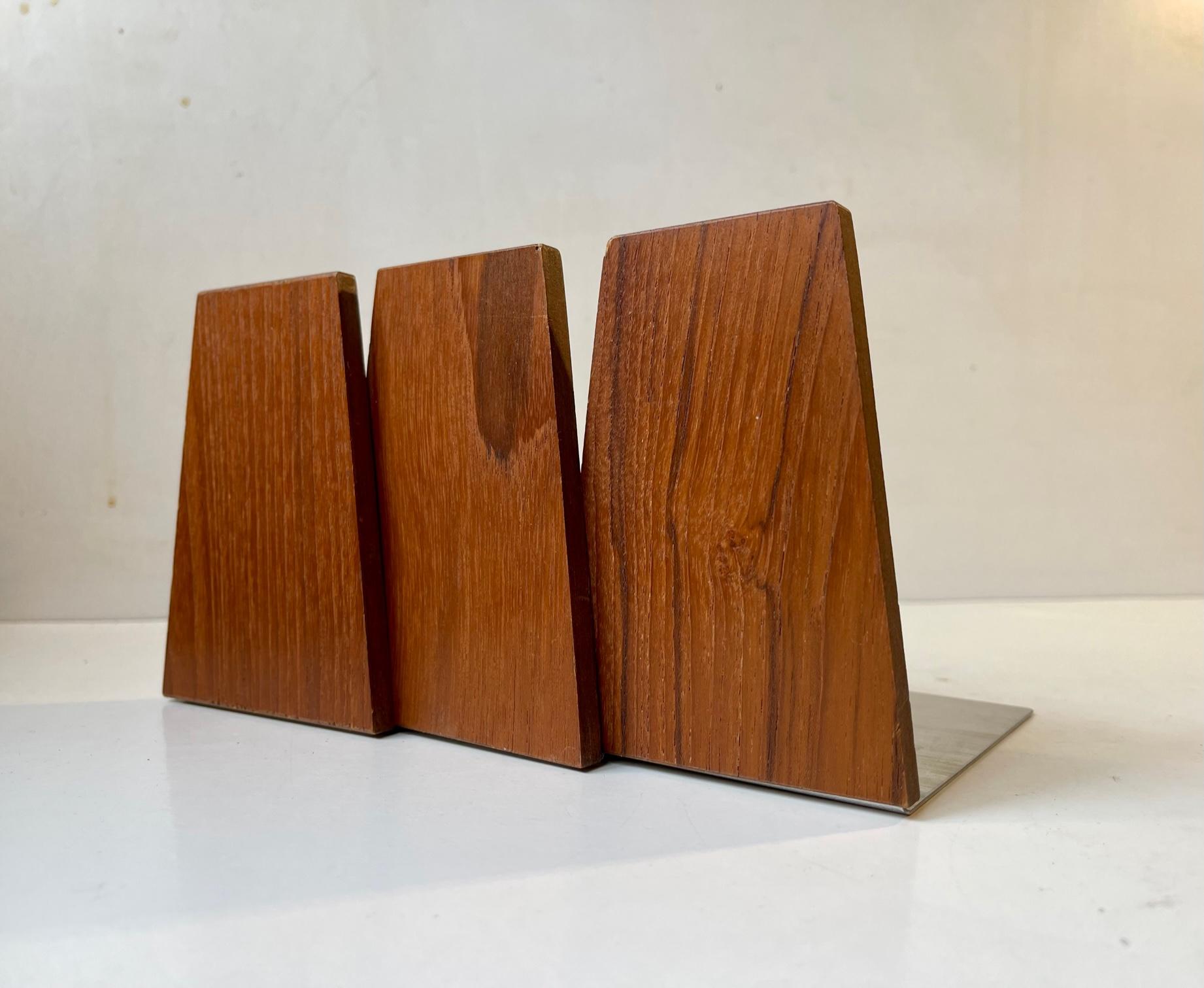 A set of 3 bookends in teak with metall rest's probably manufactured by either FM Møbler or ESA in Denmark during the 1960s. Measurements: Heights: 12 cm, Dept: 11 cm. The price is for the set of 3.