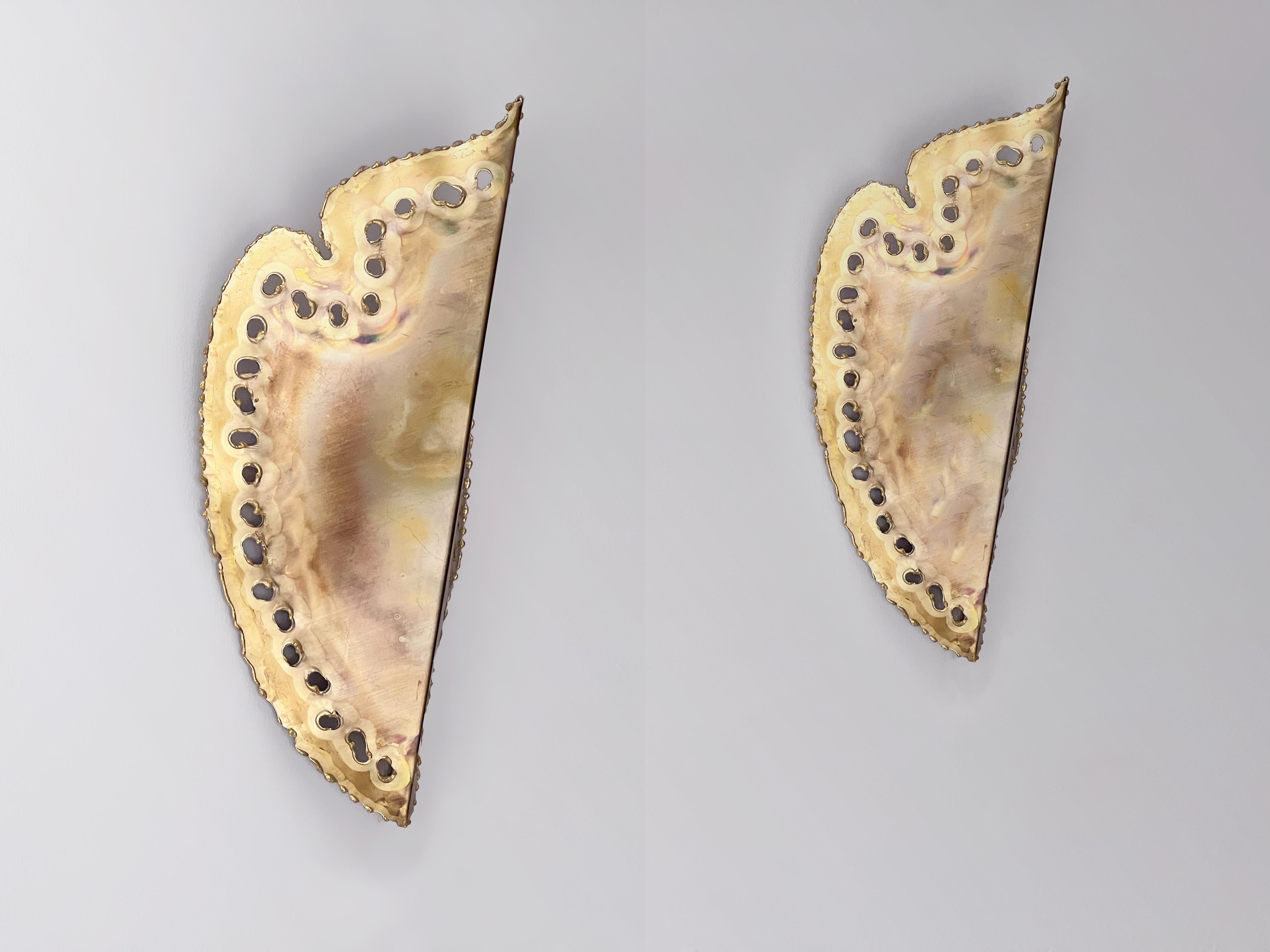 A pair of Scandinavian mid-century brutalist sconces by Svend Aage Holm-Sørensen. Leaf shaped brass with a vertical crease at the center, torch cut with perforations along the edges. Labeled “Holm-Sørensen & Co, Made In Denmark”. Holds one E14 bulb