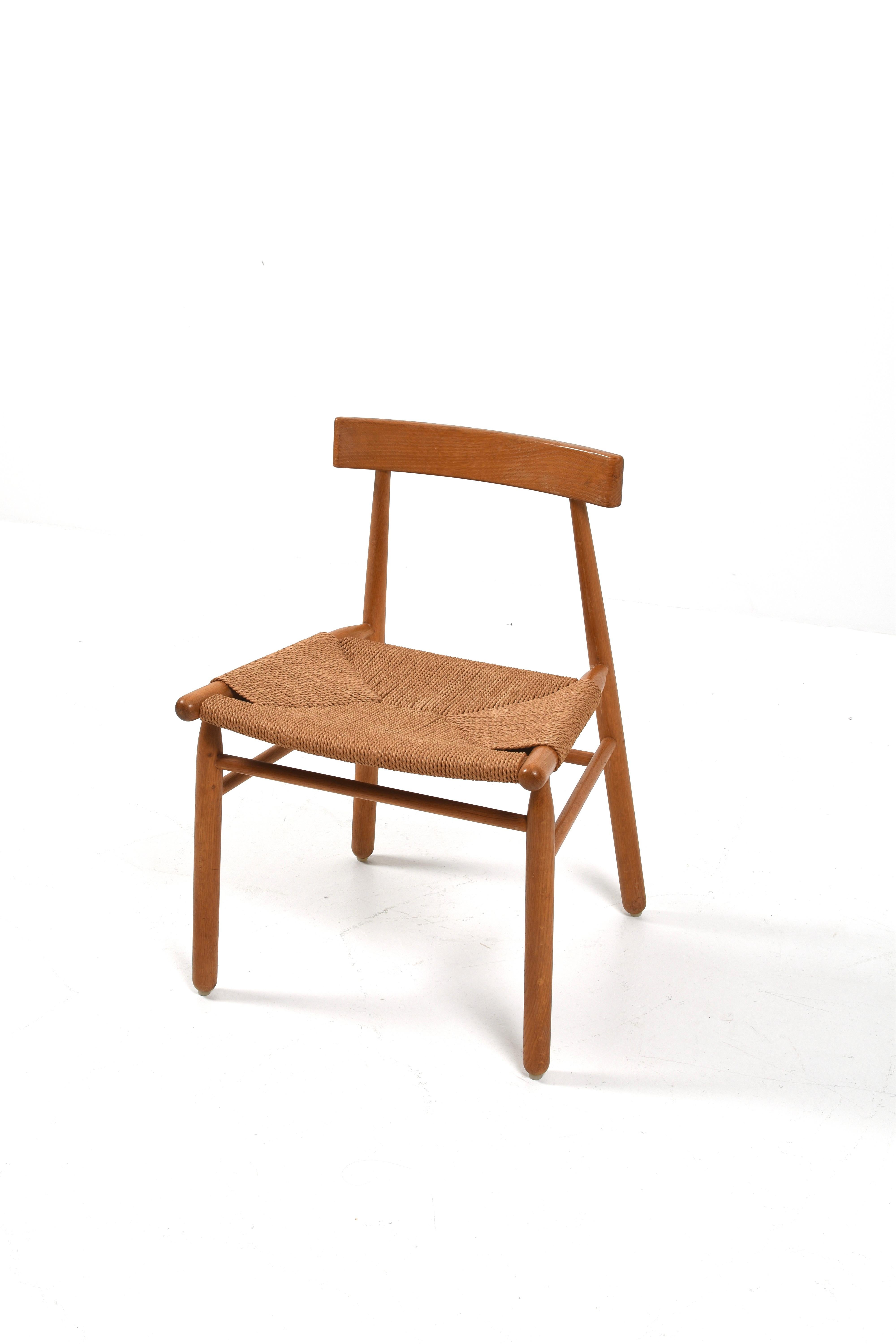 Silla danesa de mediados de siglo, de la década de 1950, bellamente elaborada. Este diseño moderno escandinavo combina sencillez y funcionalidad con un fuerte sentido de la artesanía. La estructura de roble macizo está suavemente patinada y muestra