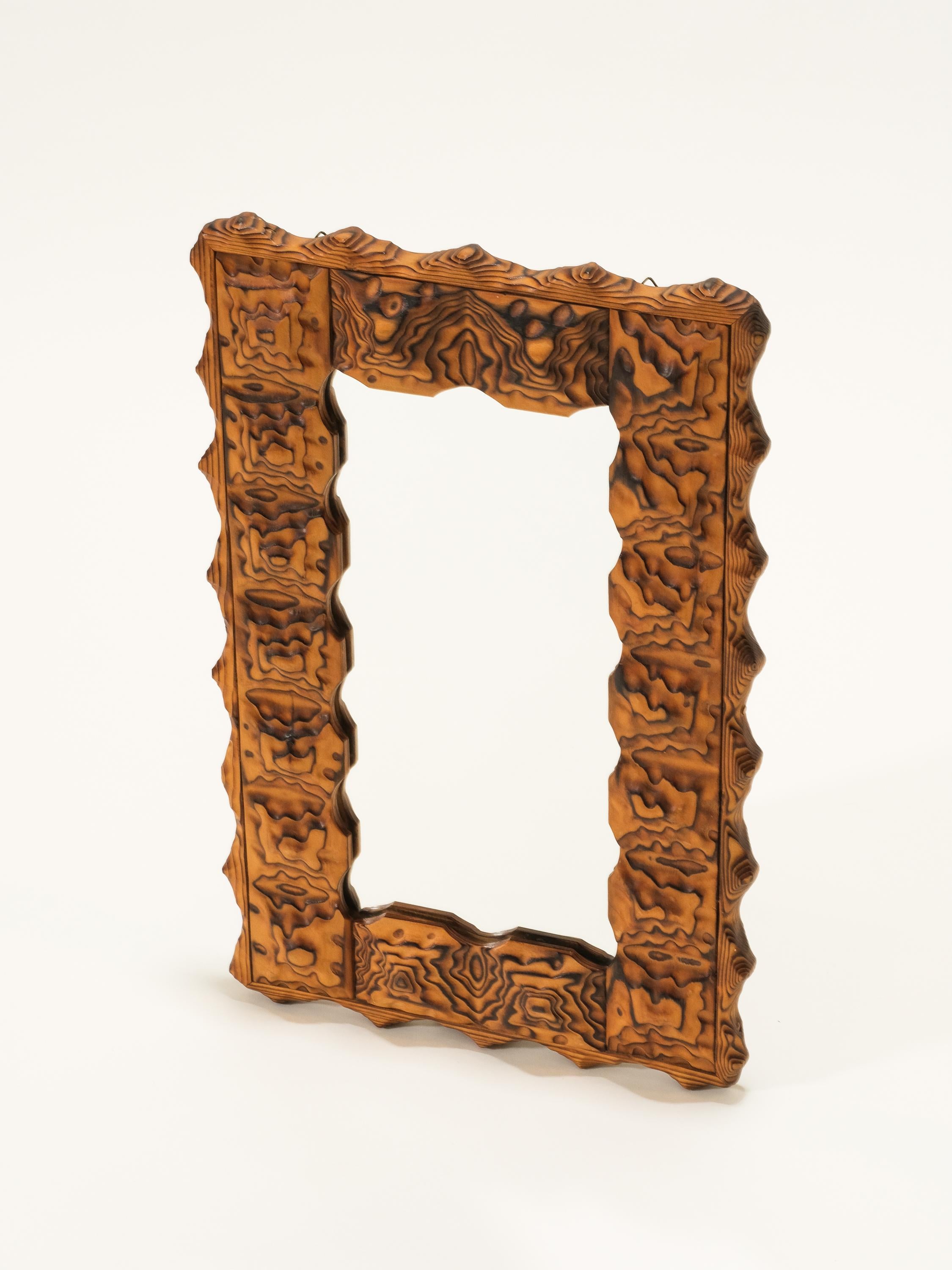 A unique charred wooden wall mirror produced in Finland, 1970s. Burnmarked by the maker.