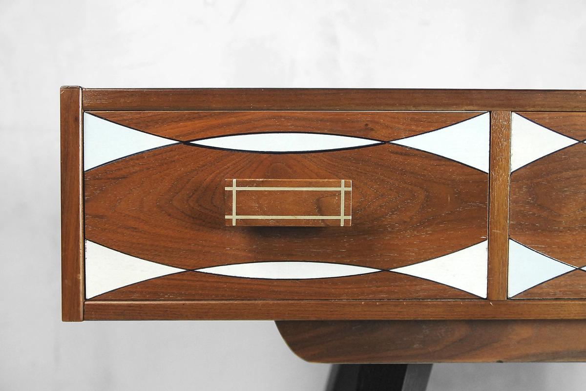 This Scandinavian Modern console table was produced in Sweden during the 1960s. It is finished in walnut wood with regular grain in deep brown. The cabinet has a three drawers with hand painted pattern in light blue and white. The chest has been