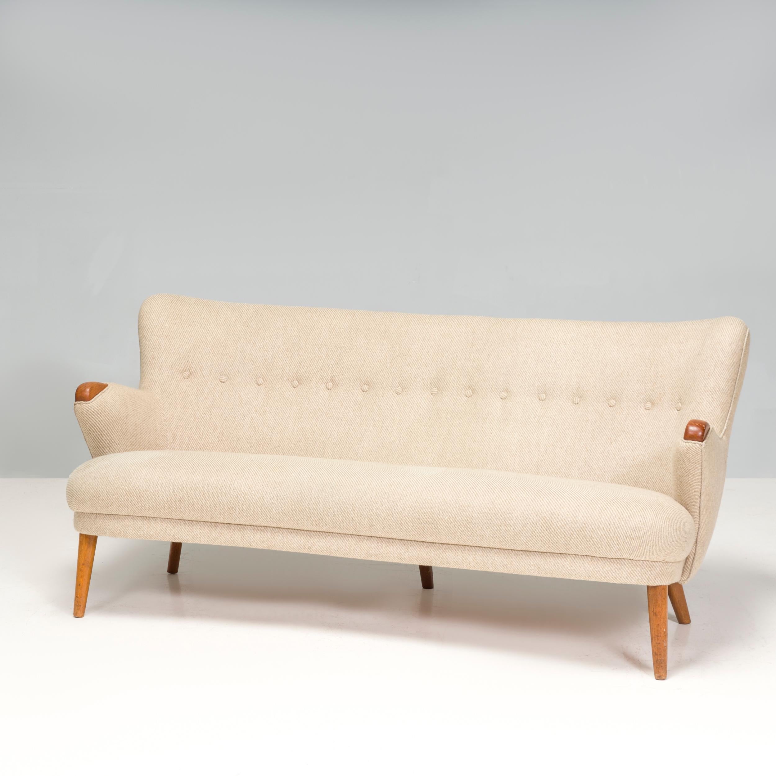 Mid-Century Modern Danish sofa in the style of Kurt Olsen 
This organic form curved sofa is upholstered in a gorgeous tan wool mix fabric.

Shelved back buttoned sofa with teak legs and handcrafted wood frame with sculpted teak arms pads. Original