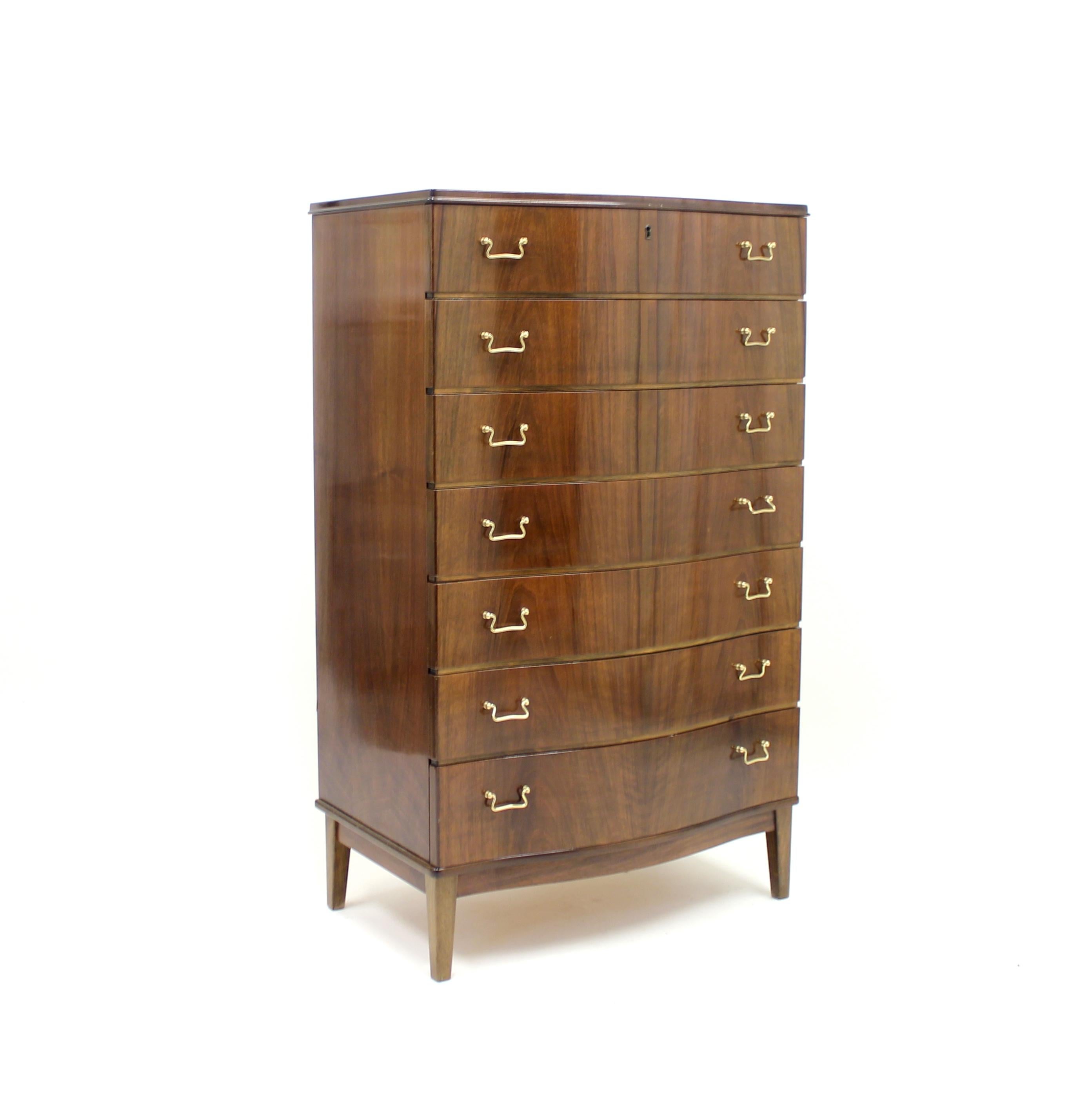 Scandinavian, most likely Danish, chest of drawers in walnut with curved front and brass handles. Unknown manufacturer. Made in circa 1950s. Ware consistent with age and use.