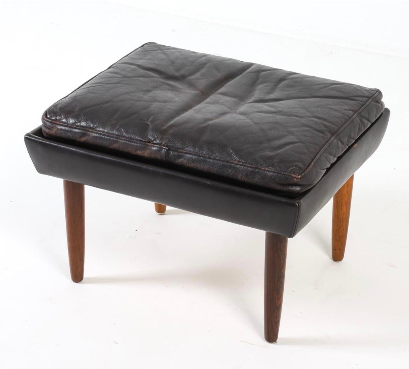 Mid Century Scandinavian Danish Modern Ottoman oder Hocker aus schwarzem Leder. Schwarze Lederpolsterung und Kissen mit 4 konischen Teakholzbeinen. Guter Vintage-Zustand. Verwendung als Hocker, Bank oder Ottomane.

Lokale Abholung in Brooklyn NYC