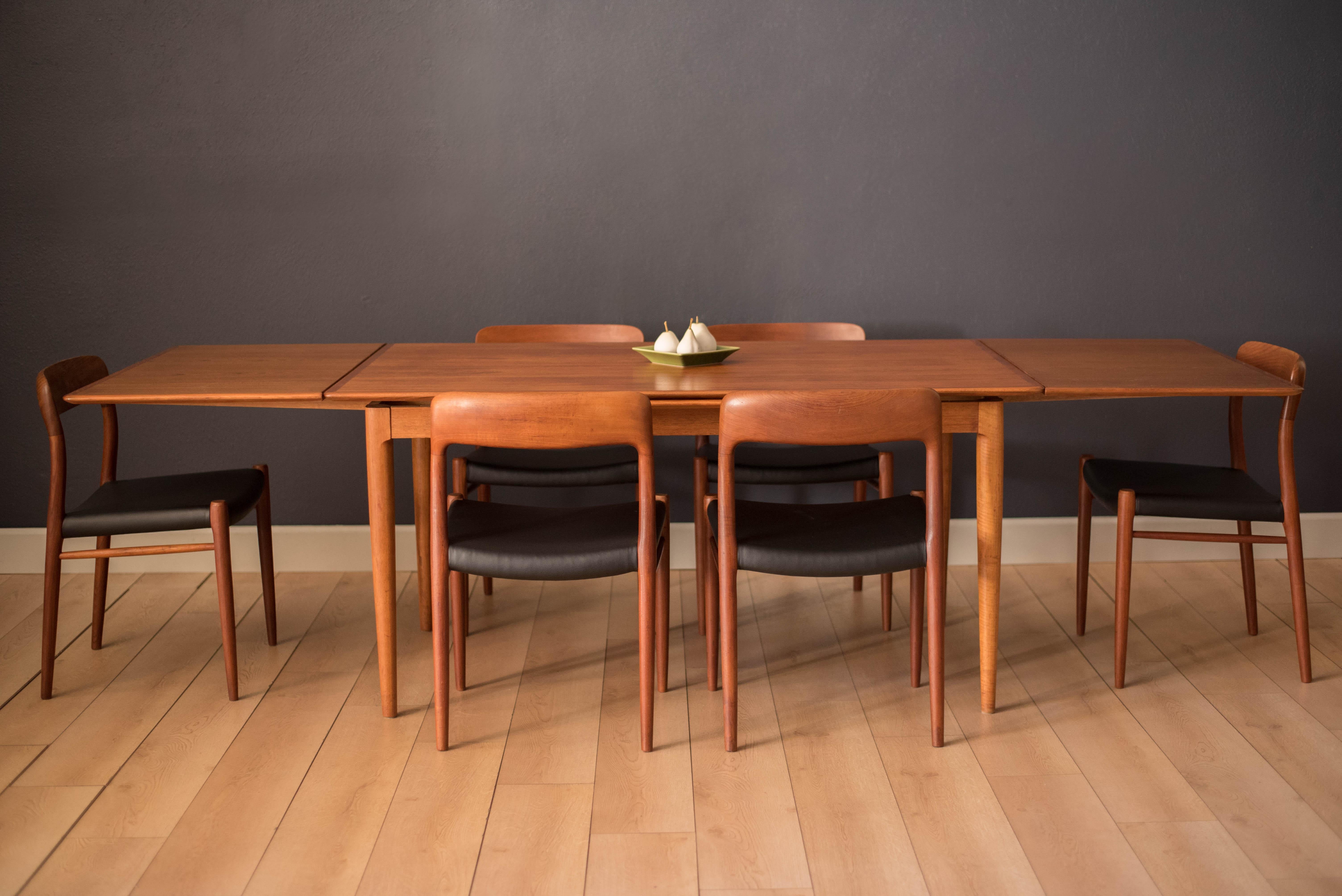 Vintage draw leaf expandable dining table in teak, circa 1960s. This piece features unique sculpted details and extends with two leaves that cleverly store underneath the table. 


Fully extended 103.25