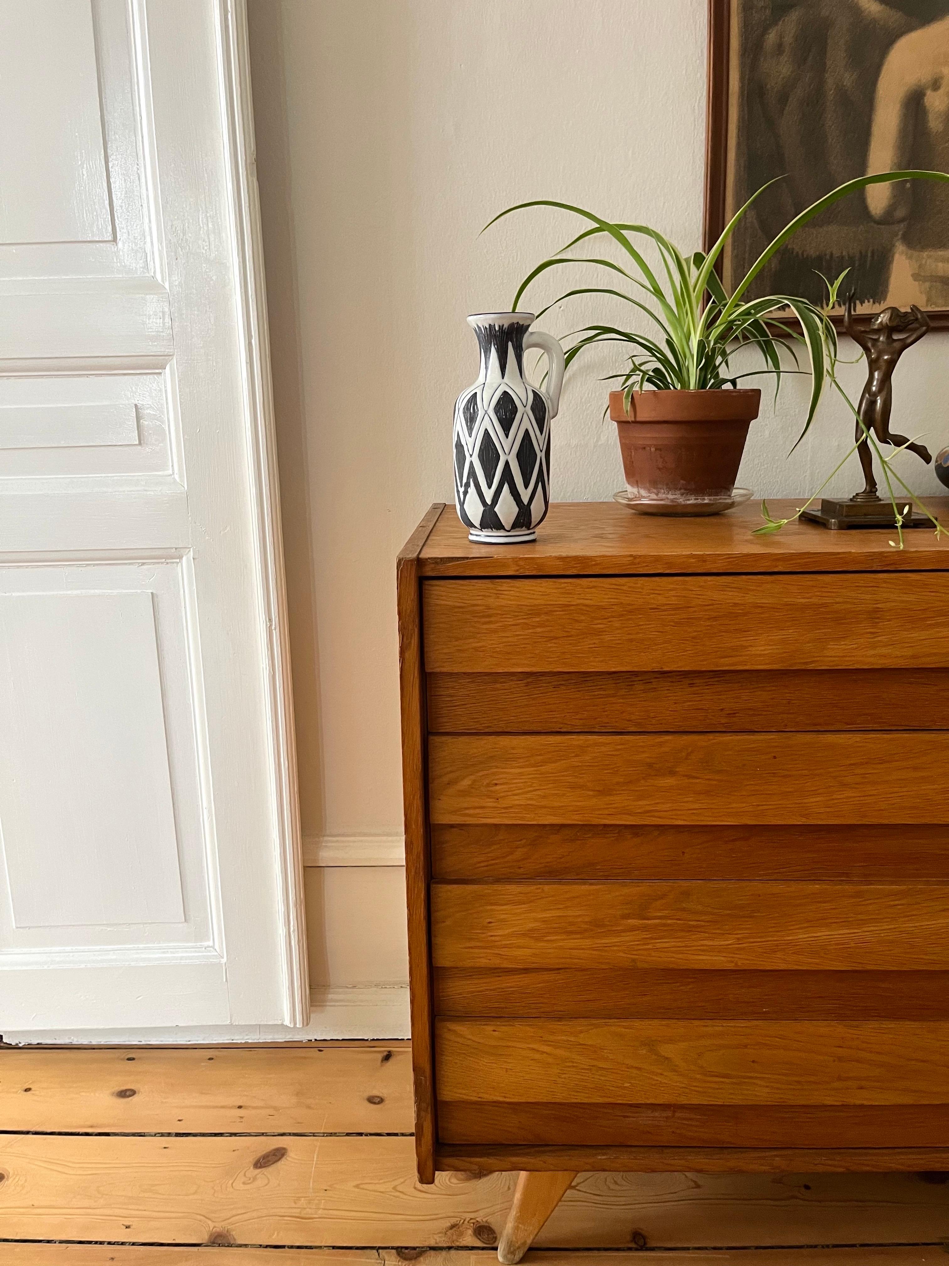 Brocca in ceramica artigianale scandinava di metà secolo, anni '50

Elegante brocca/vaso in ceramica scandinava risalente agli anni Cinquanta. Il pezzo è realizzato a mano e smaltato nel caratteristico stile moderno di metà secolo, che combina la