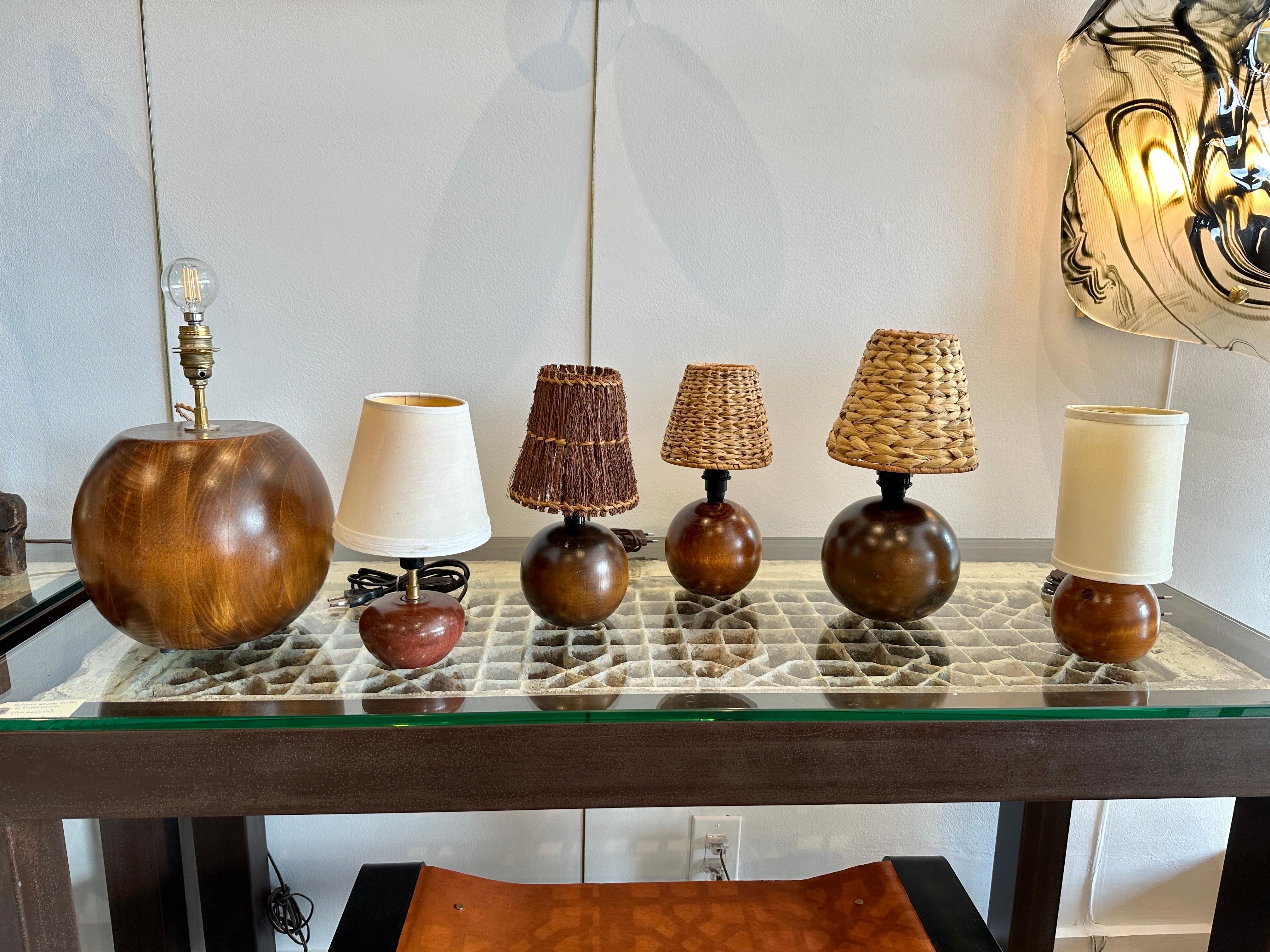 Cette lampe en teck en forme de globe est composée de tranches de bois formées par des artisans scandinaves pour créer cette lampe étonnamment organique. Le câblage a été refait à neuf avec des câbles en soie. NOTE : il y a un groupe étonnant de ces