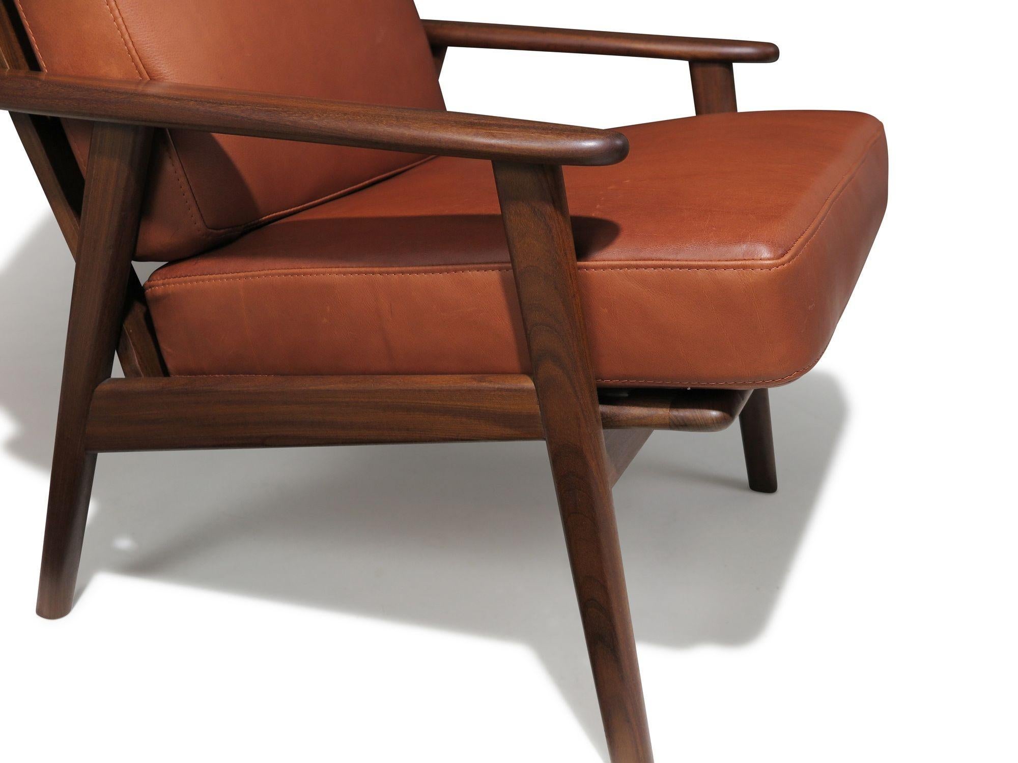 Comfortable mid-century lounge chairs, handcrafted from solid hardwood and featuring newly upholstered inner-spring cushions in a subtle brown-hued leather. Crafted with precision and fine joinery, these chairs are sturdy and built to last for