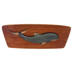 Placa escandinava de mediados de siglo con una escultura de una ballena de metal sobre madera de teca