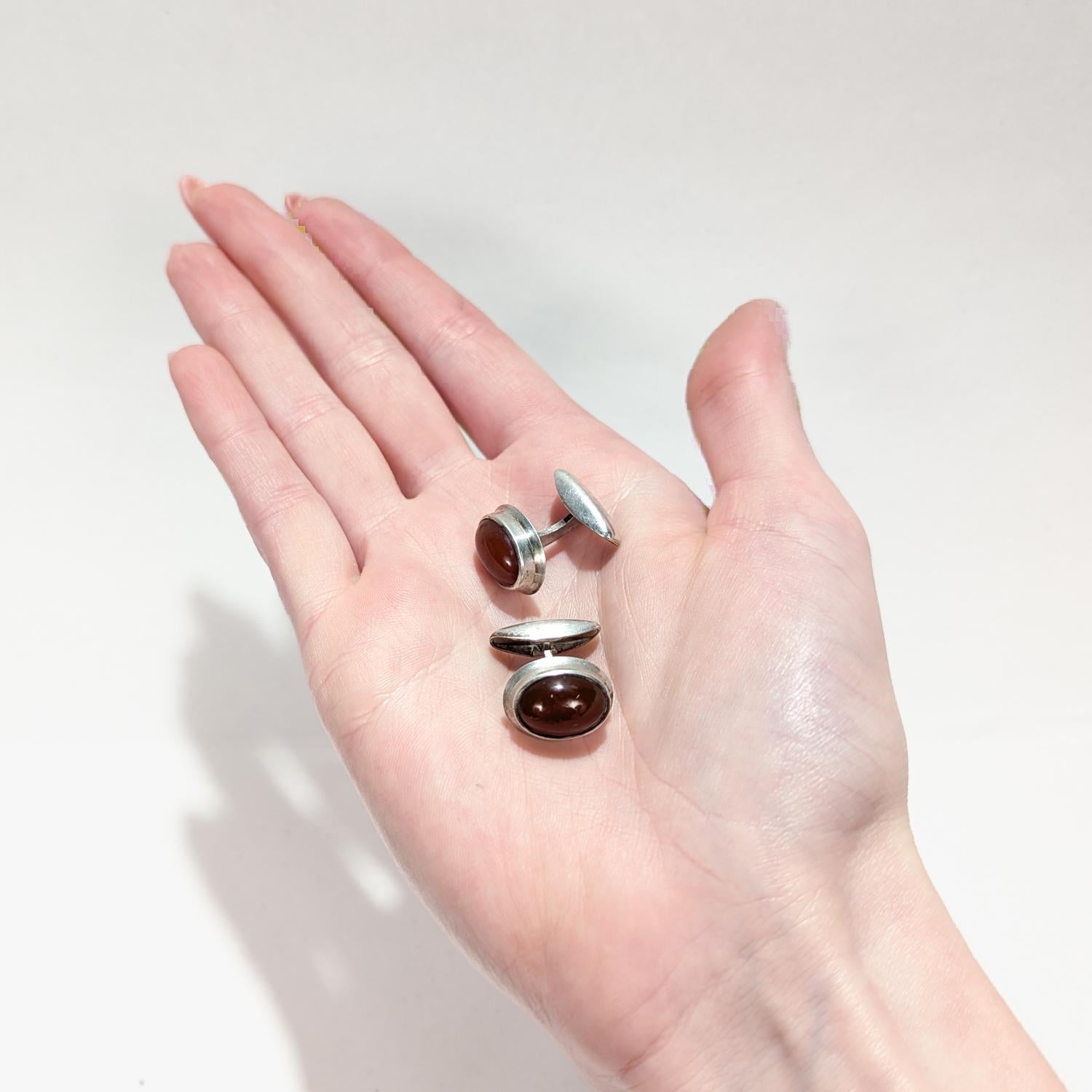 Ein schönes Paar schwedischer Manschettenknöpfe aus der Mitte des Jahrhunderts.

Aus 830 Feinsilber.

Jedes Stück ist mit ovalen Karneol-Cabochons in einer hohen Silberfassung eingefasst.

Einfach ein wunderschönes Paar klassisch gestalteter