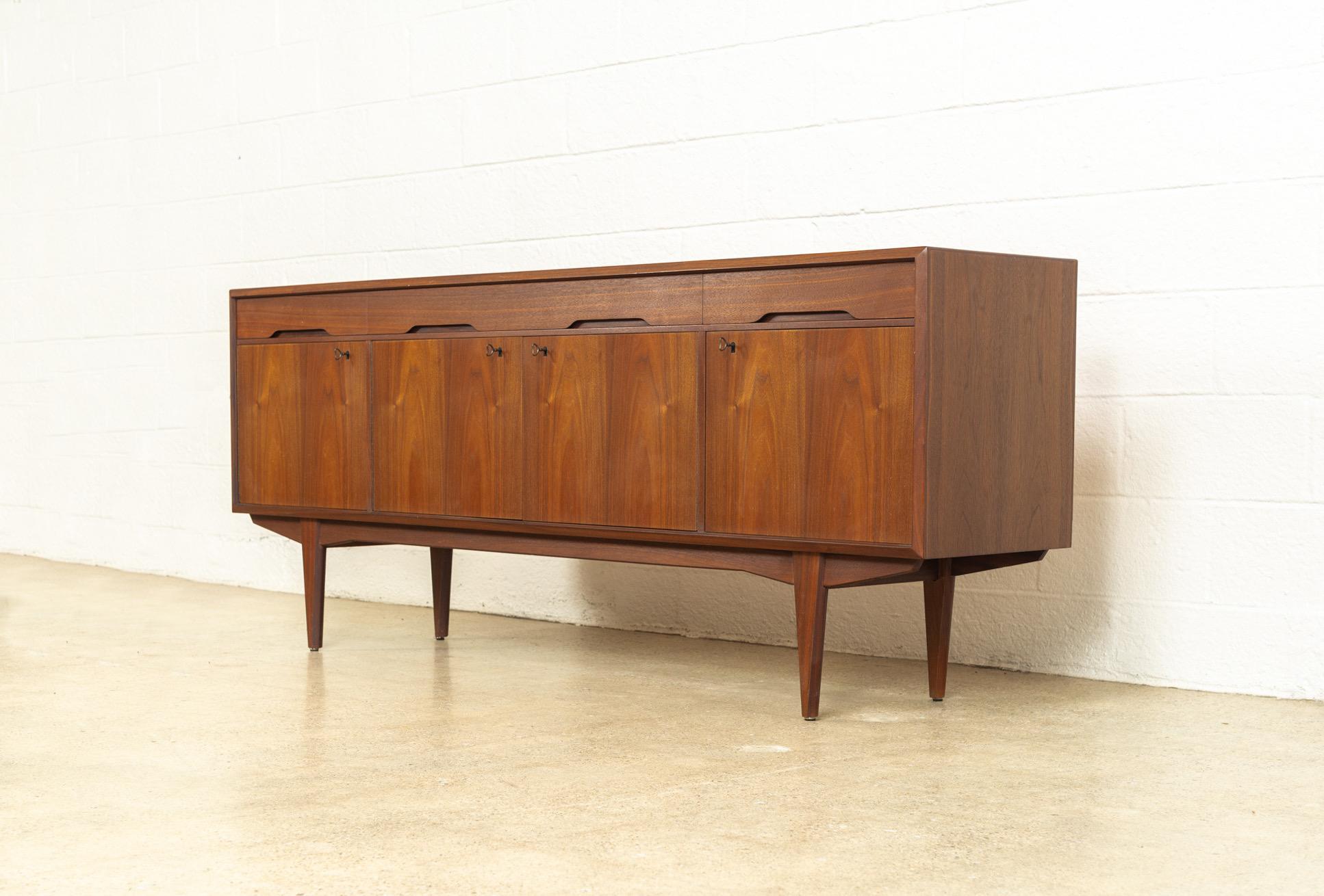 This vintage midcentury Scandinavian Modern credenza sideboard was designed by Alf Aarseth for Gustav Bahus and made in Norway circa 1960. Exceptionally crafted from walnut with beautiful natural grain, this extra wide cabinet features three