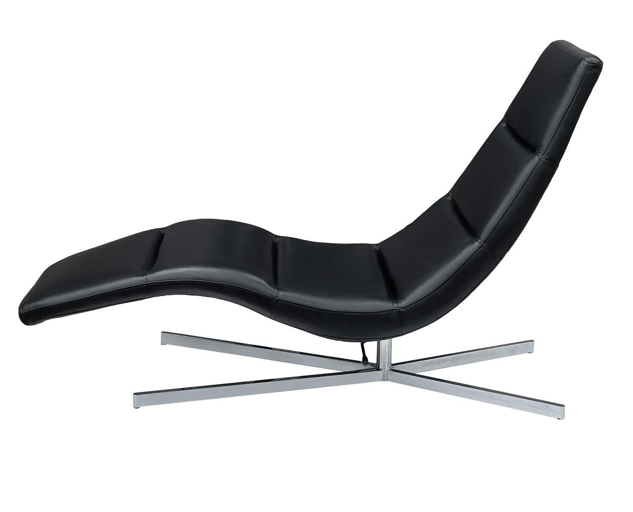 A sleek, simple modern lounge probably Scandinavian circa 1990's. It features fine black leather with large chrome X base. Very good condition and ready for use.