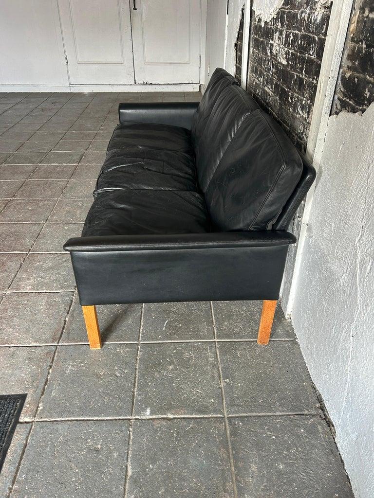 Magnifique canapé en cuir noir The Modern Scandinavian Modern, conçu par Hans Olsen. Tous les coussins d'origine en cuir noir souple garnis de duvet. Le canapé est en bon état vintage toutes les sangles sont bonnes avec des pieds en bouleau blond