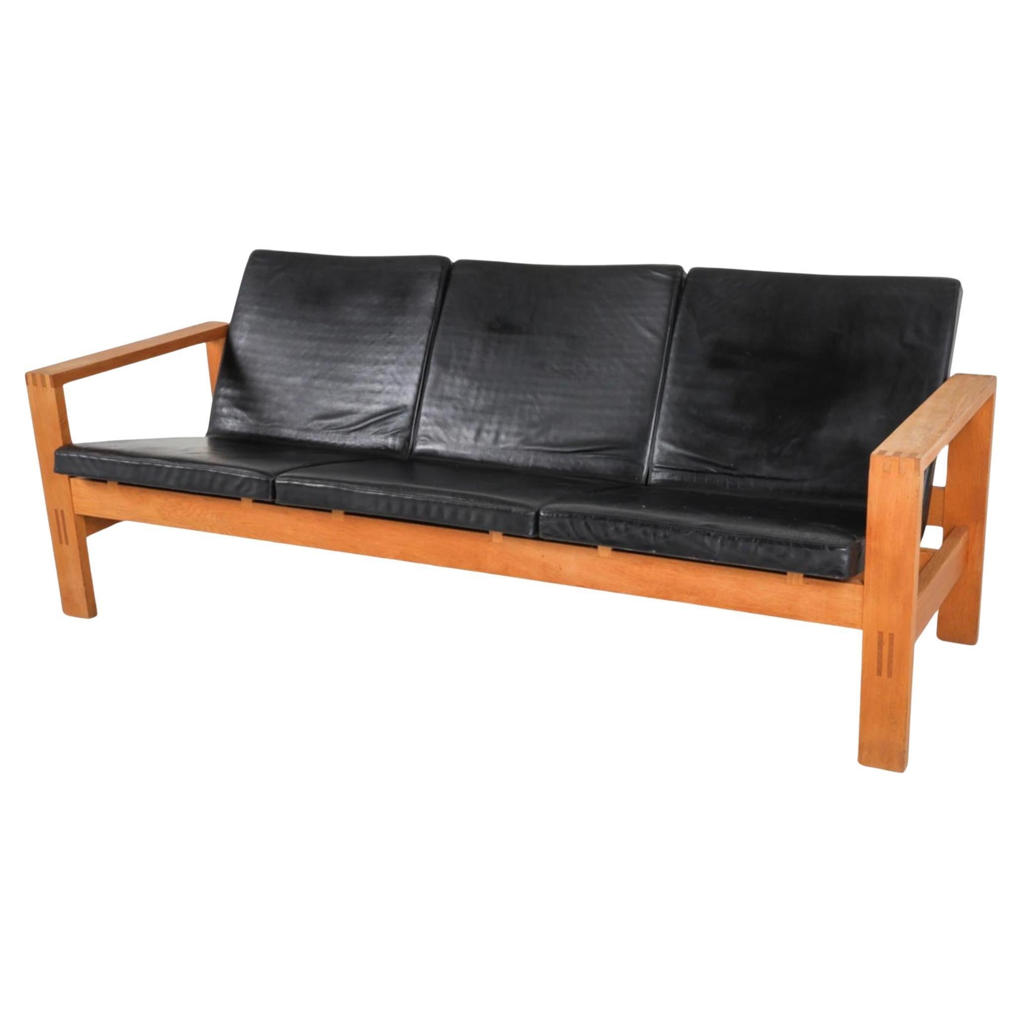 Scandinavian modern oak 3 seat sofa made in Sweden. Has 3 black seat cushions. Upholstery is black leather foam is high quality and in great condition. The frame is very sturdy and made jointed oak blonde wood. Very solid. Great for home, cabin in