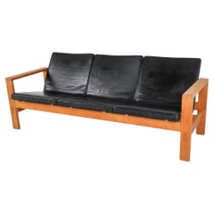 Divano a 3 posti in pelle nera in quercia di The Modern Scandinavian, prodotto in Svezia.