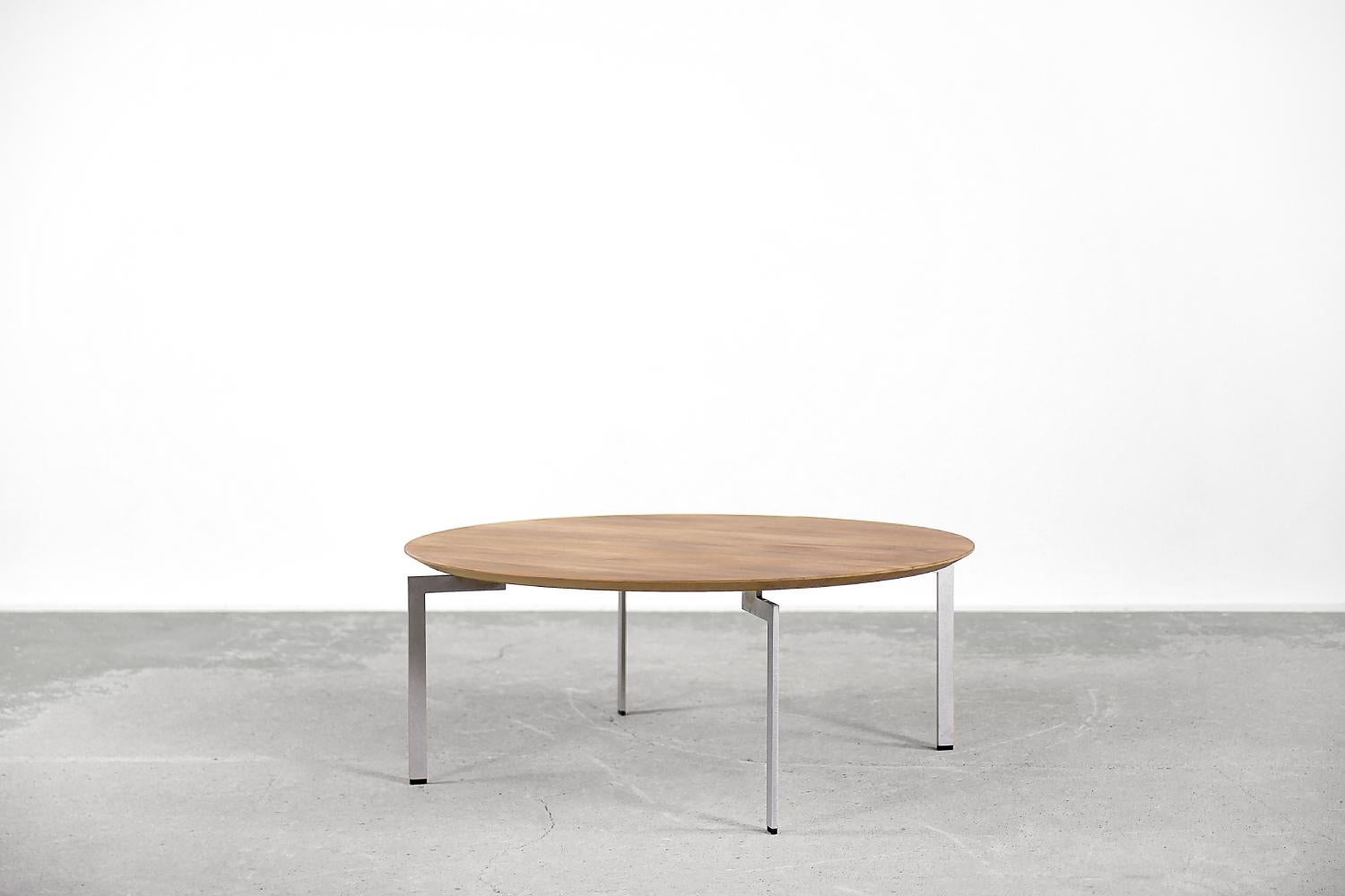 The Trippo round table was designed by Ulle Christiansson for the Swedish manufactory Karl Andersson & Söner at the end of the 20th century. It is finished with wood. It has slender solid steel legs with a matte finish. The Trippo table series is