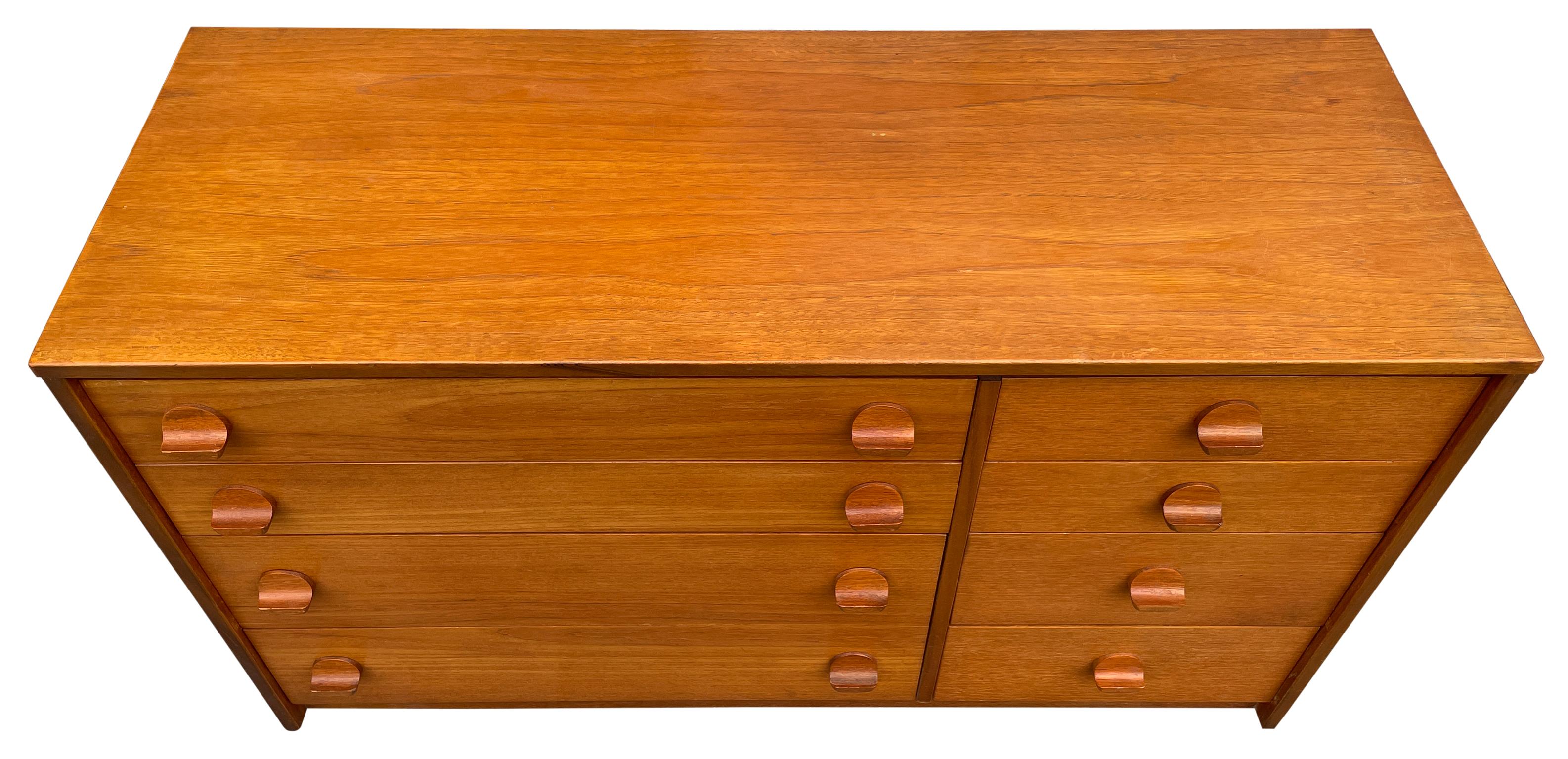 Mid Century small Scandinavian Modern Teak Low 8 drawer asymmetrical dresser by Stag. Beautiful designed Low Dresser or Credenza - dark teak wood Veneer with sculpted teak handles. Sits low on the ground with a flat base. Clean Inside and out