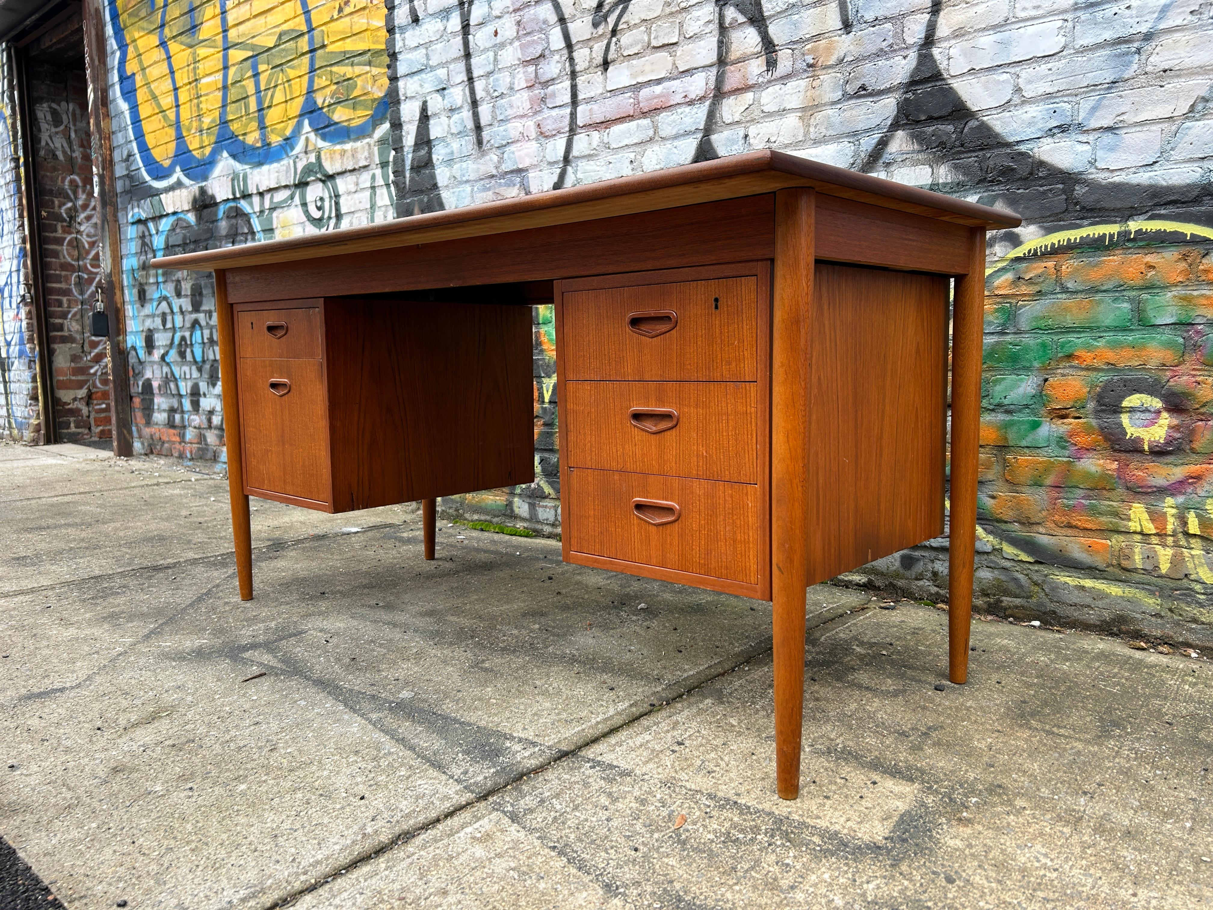 Mid Century Danish Modern teak 5 drawer desk with key. Great Danish Desk with 5 drawers with carved handles. Two of the top drawers are lockable with the brass key. desk is very beautiful Scandinavian design.  Made in Sweden. Located in Brooklyn
