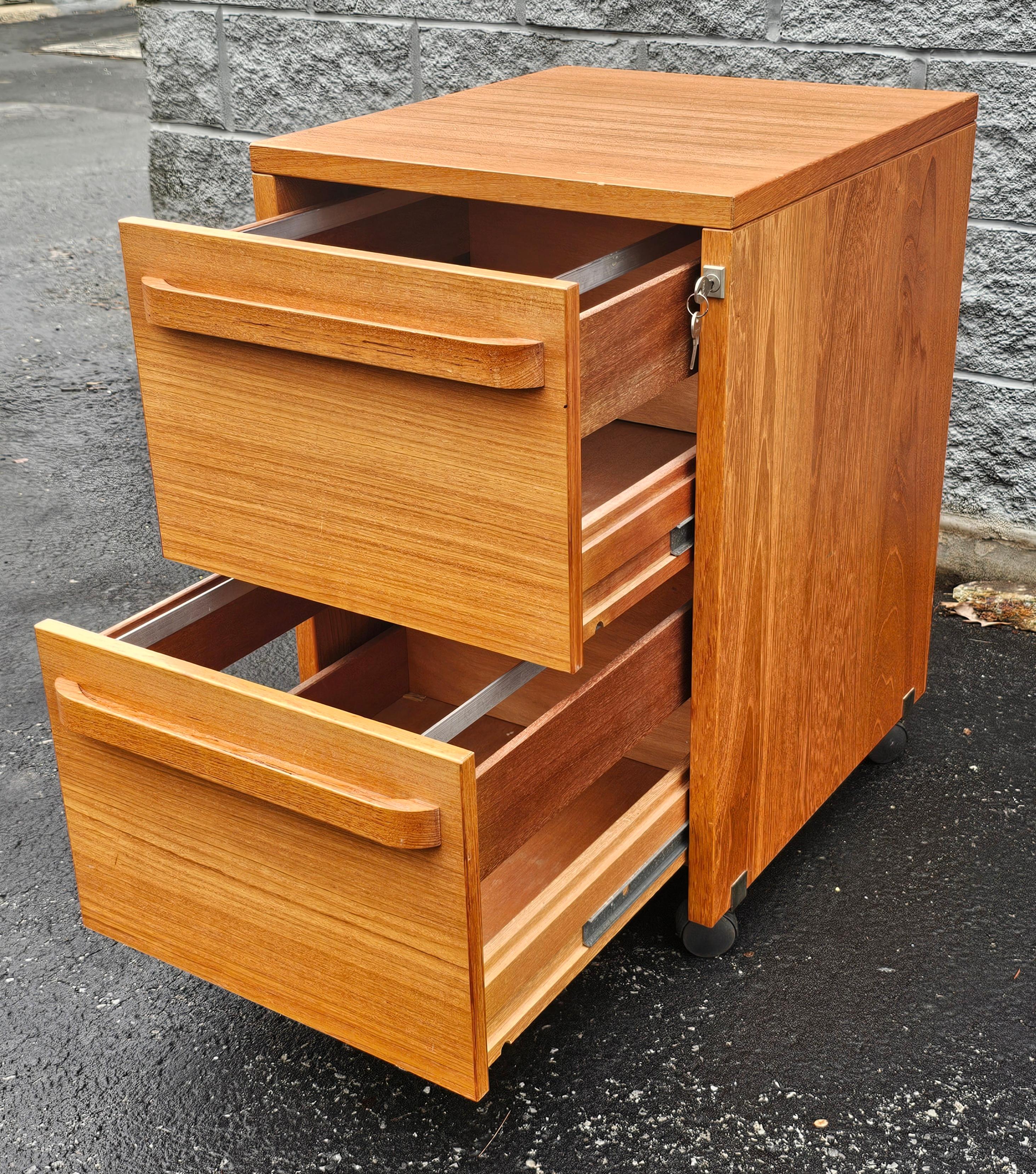 Mid-Century Scandinavian Modern Teak Two-Drawer Filing Cabinet with Lock on Wheels in great vintage condition. Adjustable for legal and letter size file holders. Measures 19