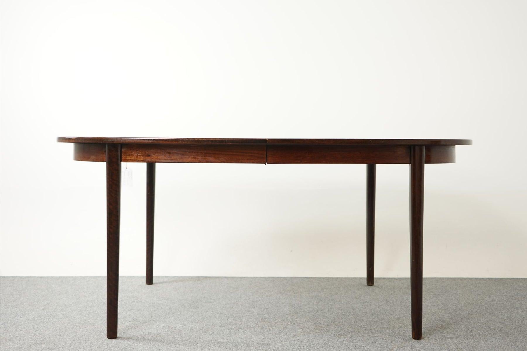 Rosewood Scandinavian dining table, circa 1960. Table top is framed in solid wood edge trim while the center panels feature highly figured veneer with book-matched grain. Expandable design makes this the perfect table for modern compact living