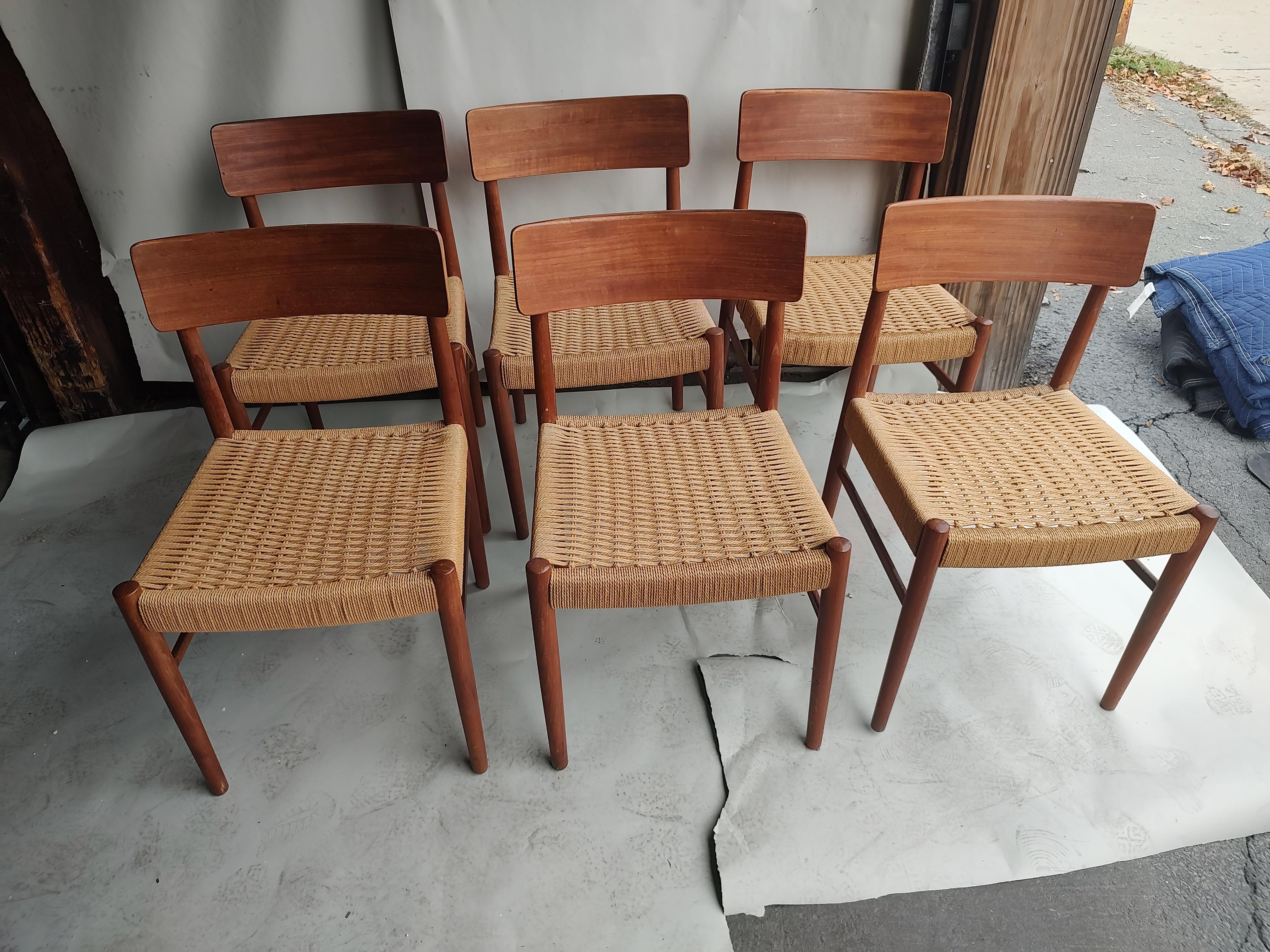 Fabulous set of six teak dining chairs with rope seats and sculpted backs. Rope is near excellent except for one chair where the rope was stained on a front corner. See pic. Other than that chairs have been gone over and glued where joints were