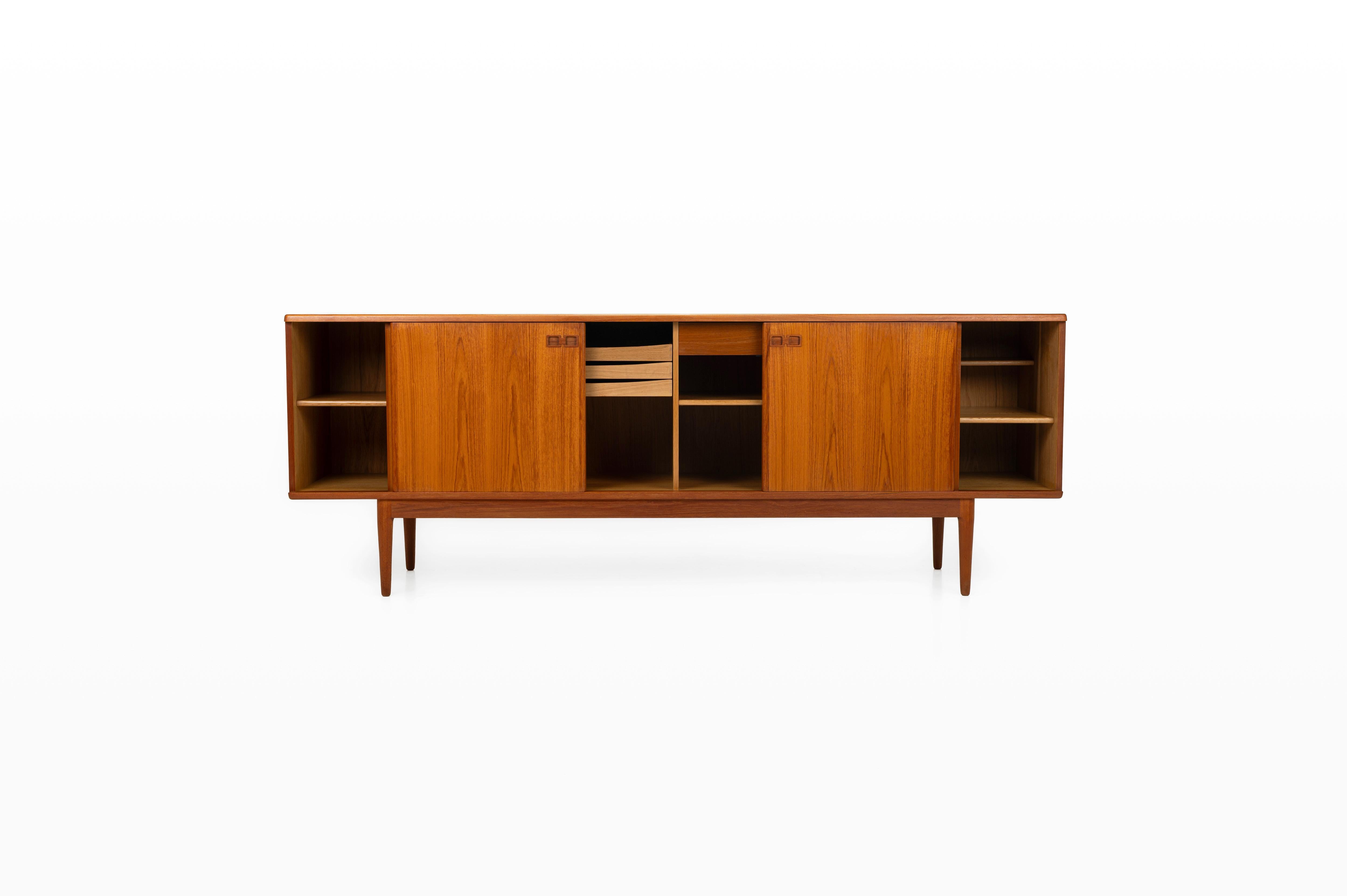 Bellissima credenza disegnata e prodotta da Christian Linneberg per Christian Linnebergs Møbelfabrik. La credenza è rifinita esternamente in teak e internamente in Oak, di altissima qualità. Ci sono quattro ante scorrevoli, cassetti interni e tanto