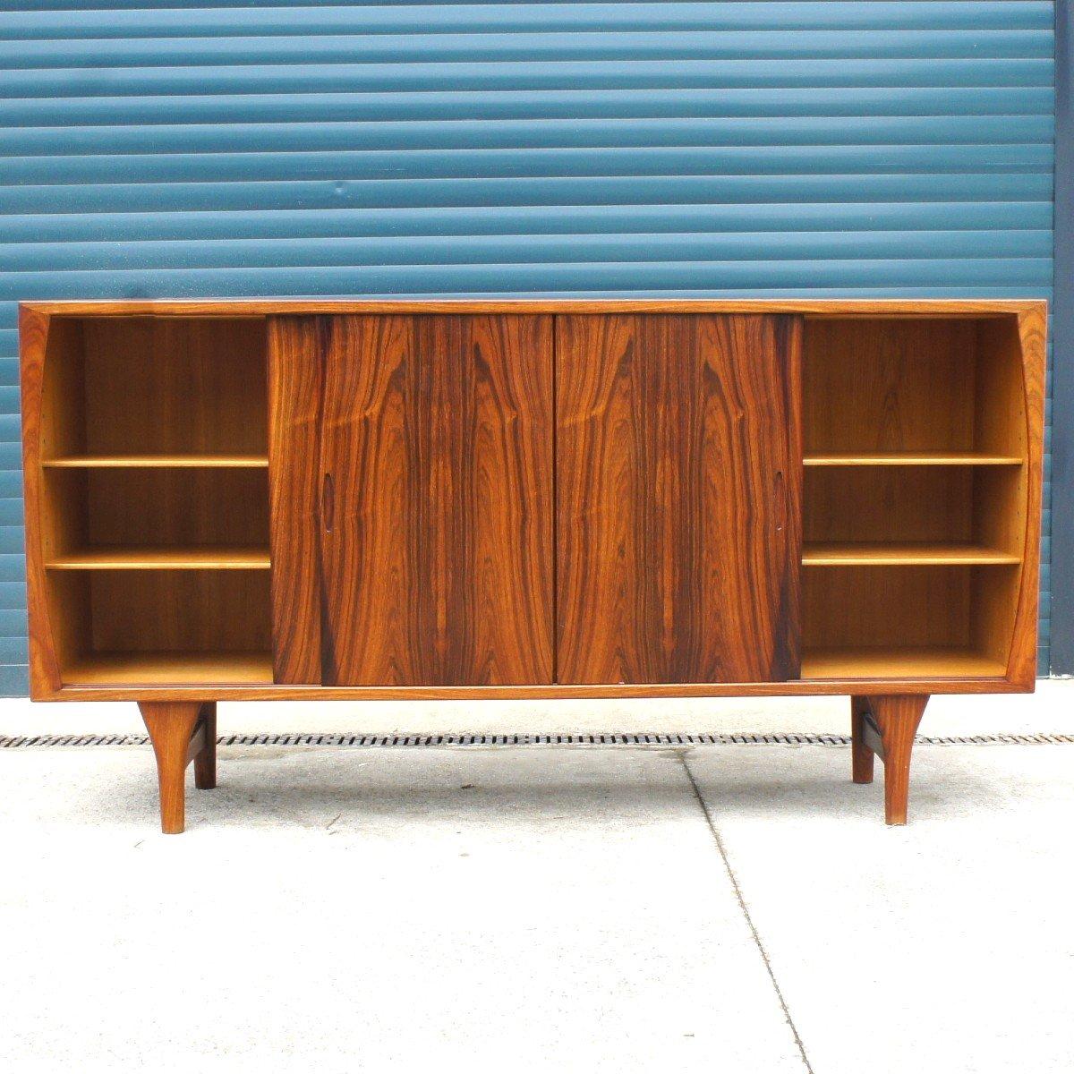 Mid century scandinavian sideboard made of rosewood from Rio. It has four sliding doors opening on a storage module of three shelves and several drawers made of light oak. It is a sober piece of furniture, with a pleasant colour contrast between the