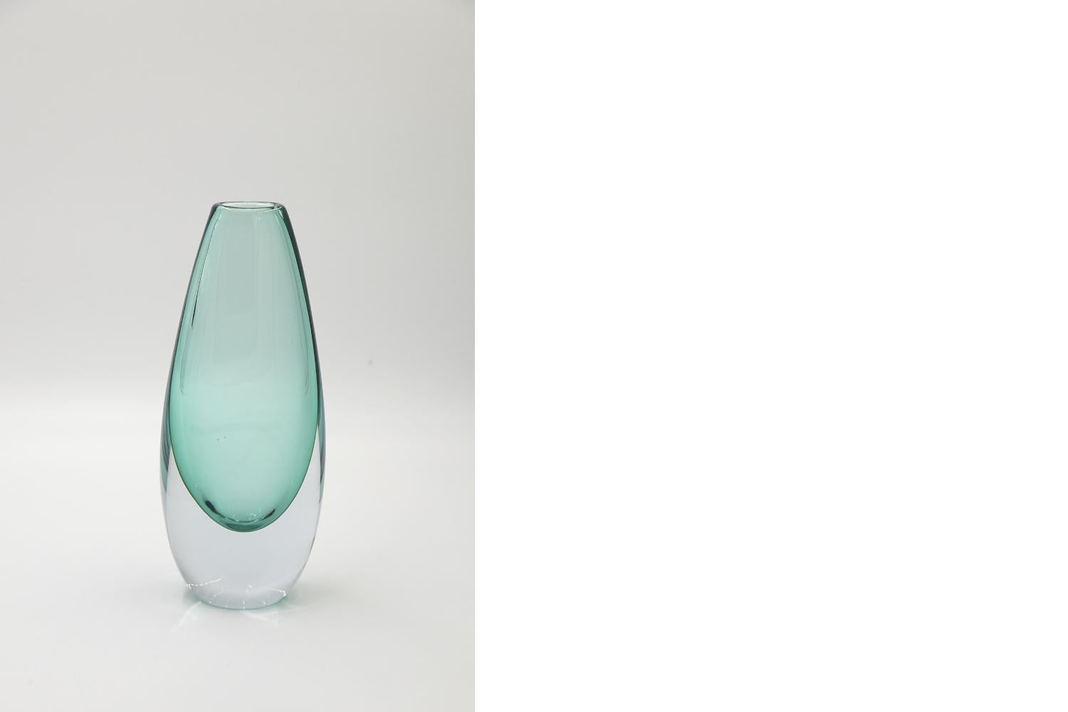 This glass vase was manufactured in Scandinavia during the 1950s. Made of art glass in the Sommerso technique, which in Italian means immersed. This technique involves repeatedly placing a colored bubble in a transparent crystal. It is a difficult