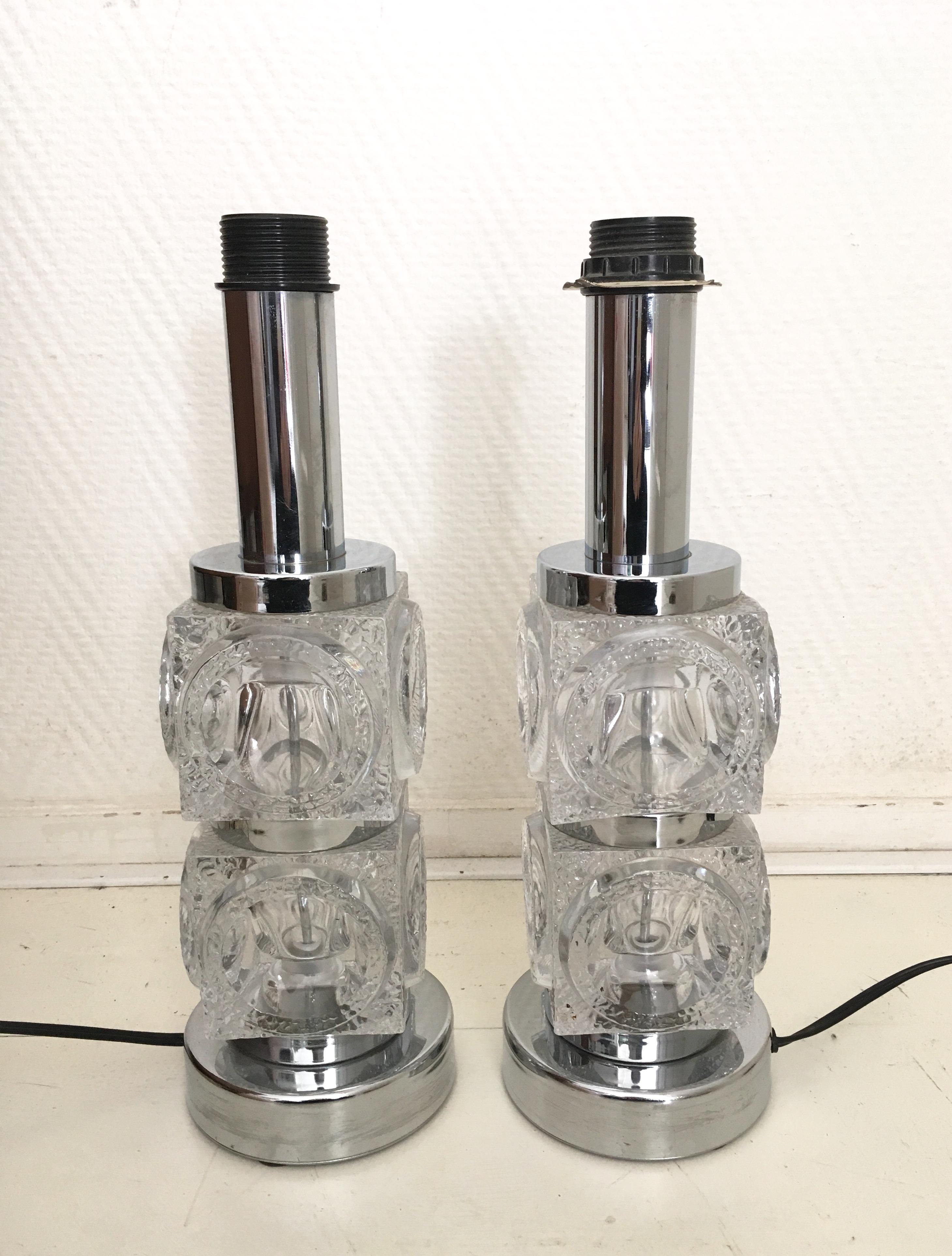 Wonderful chromed lamp base, with two stacked glass cubes. The cubes also feature Cilindric forms. The lamp base remains in original condition with European wiring, which could easily be replaced. Two pieces available. 
Feel free to make us an offer.