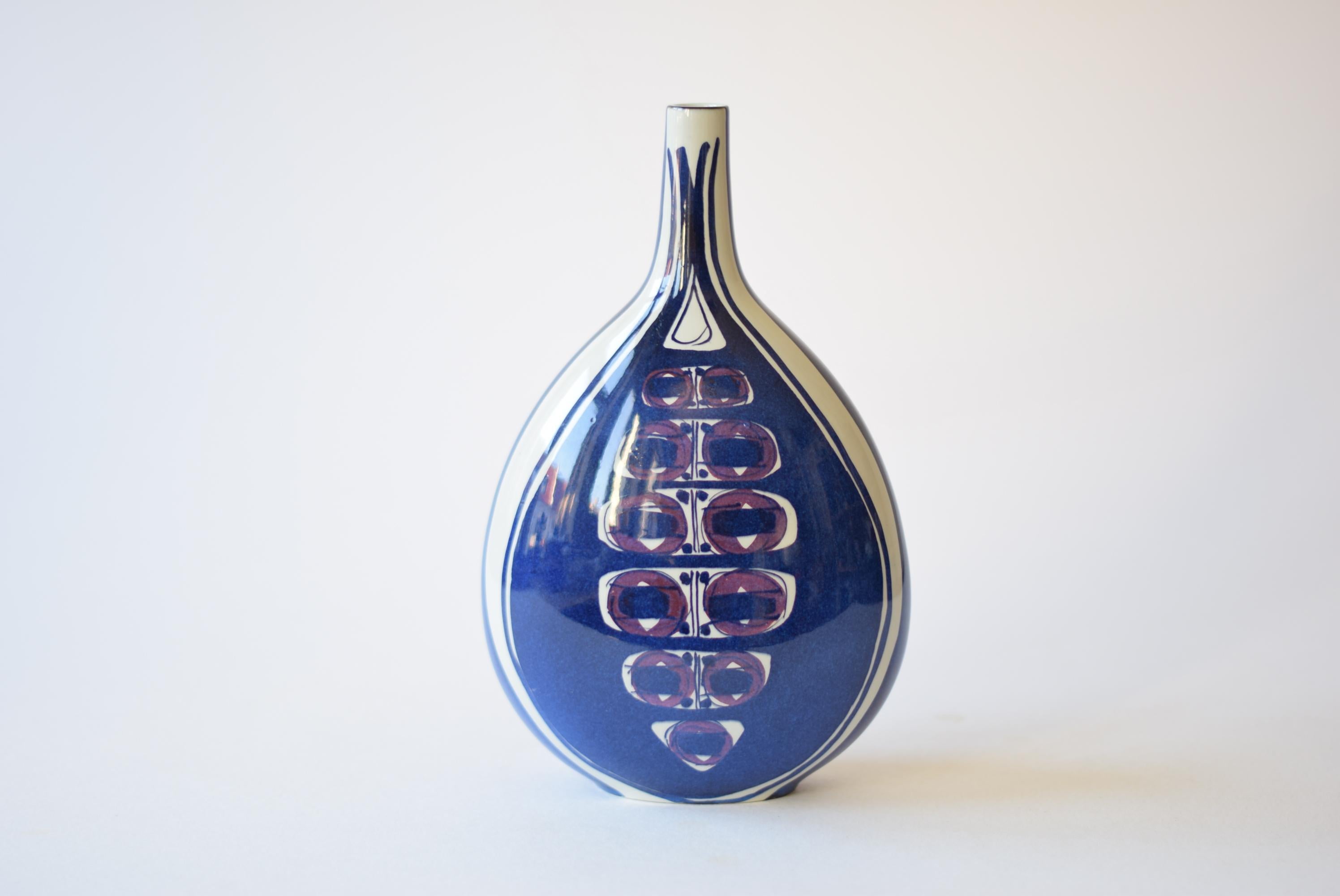 This tall bottle shaped vase from the Aluminia (later brandname Royal Copenhagen) Tenera series was designed by Inge-Lise Koefoed in the 1960s. It has a bold hand painted decor which is different on front and back. This vase is from the earliest