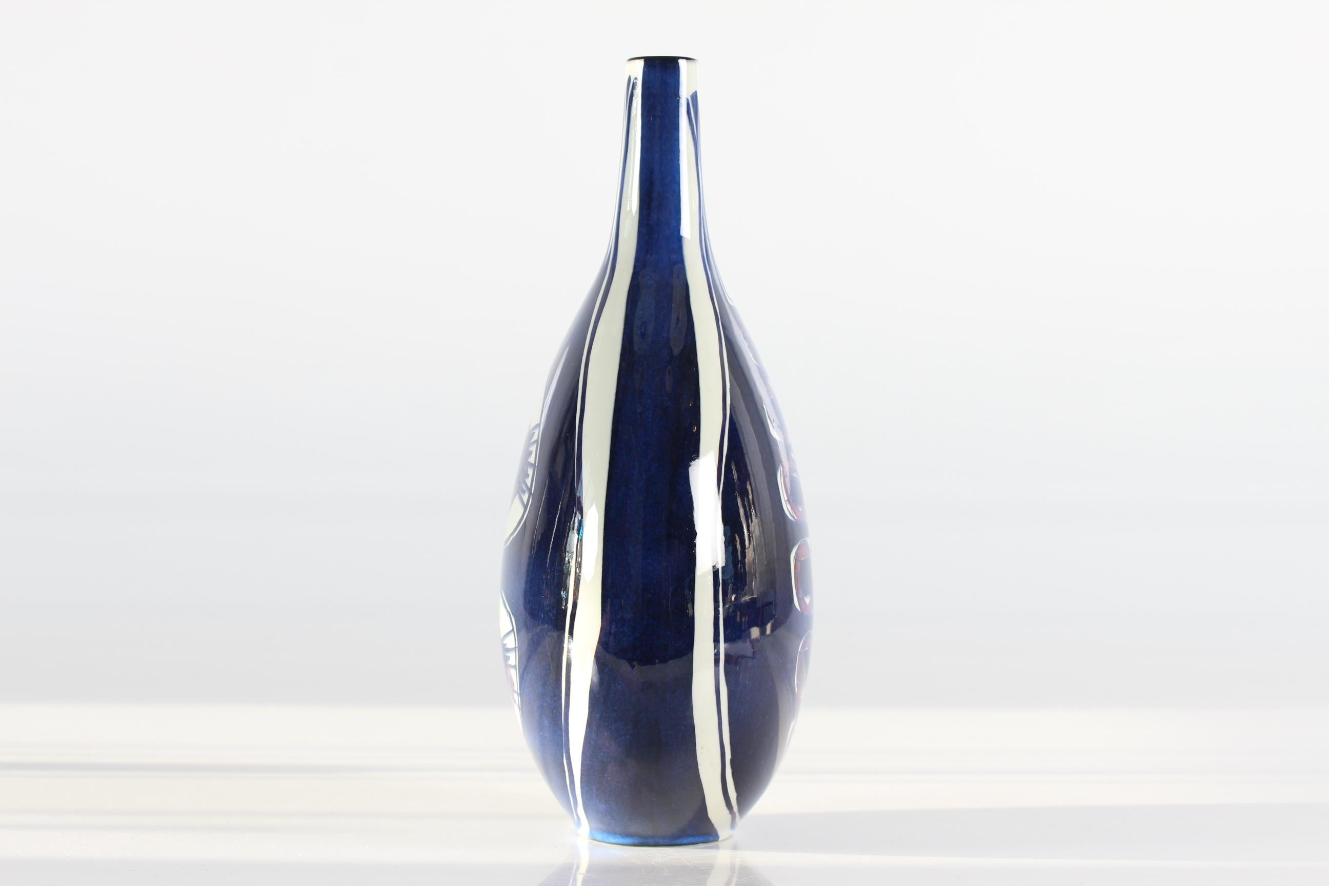 This tall bottle shaped vase from the Aluminia (later brandname Royal Copenhagen) Tenera series was designed by Inge-Lise Koefoed in the 1960s. It has a bold hand painted decor which is different on front and back. This vase is from the earliest