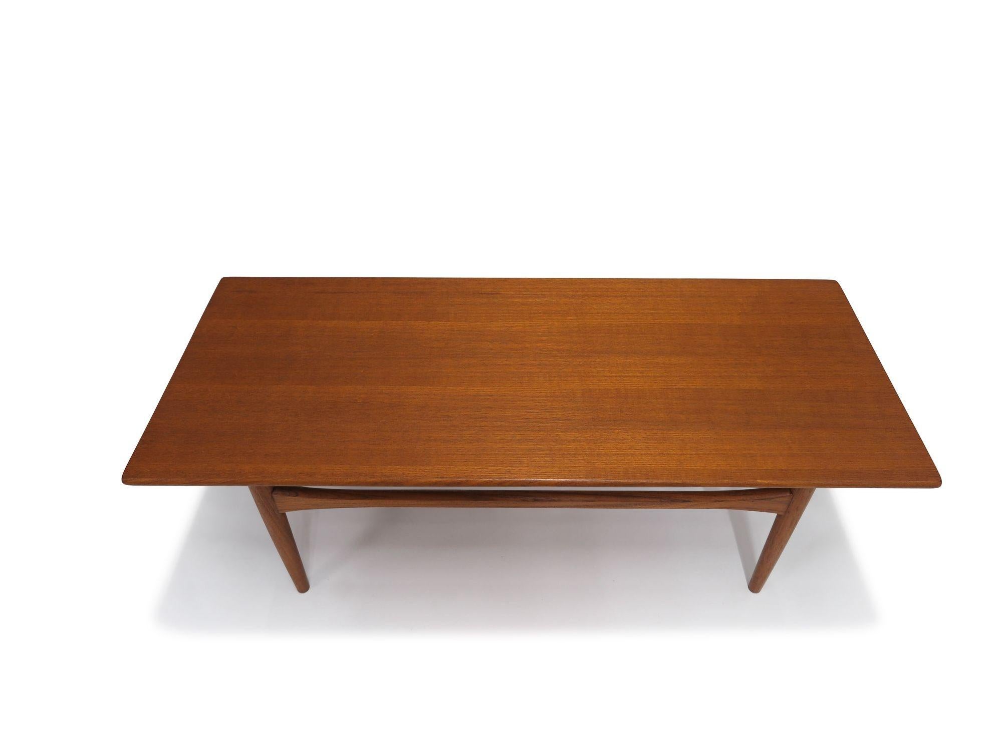 1958 Danish teak coffee table raised on tapered legs with cross stretches.
Measurements
W 48’’ x D 19,75’’ x H 15’’

