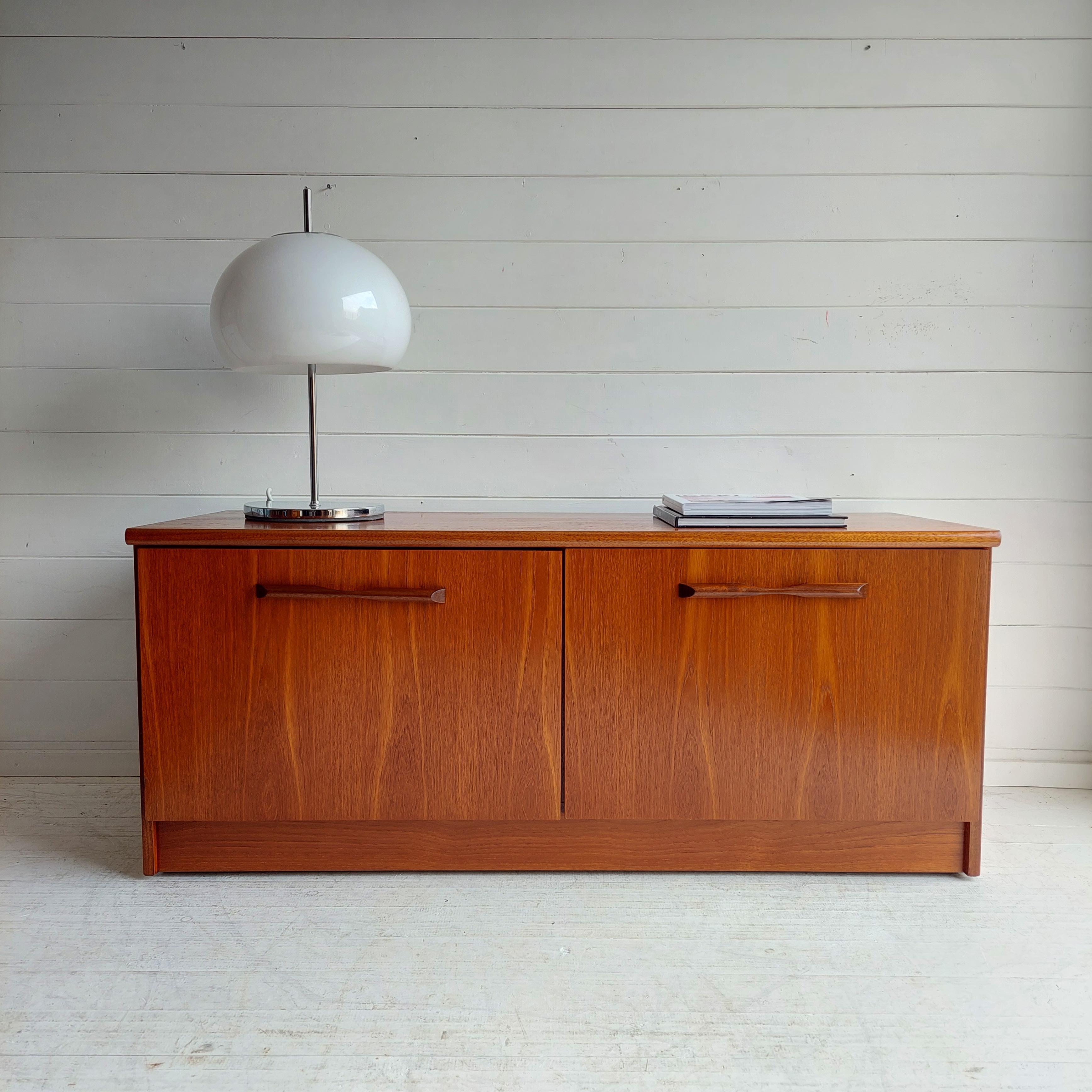 A compact and low Danish style sideboard dating back to the 1960s in teak and excellent restored condition.

There is plenty of storage with a large open section, two large doors reveal an   storage area perfect for any purpose..

A super cabinet