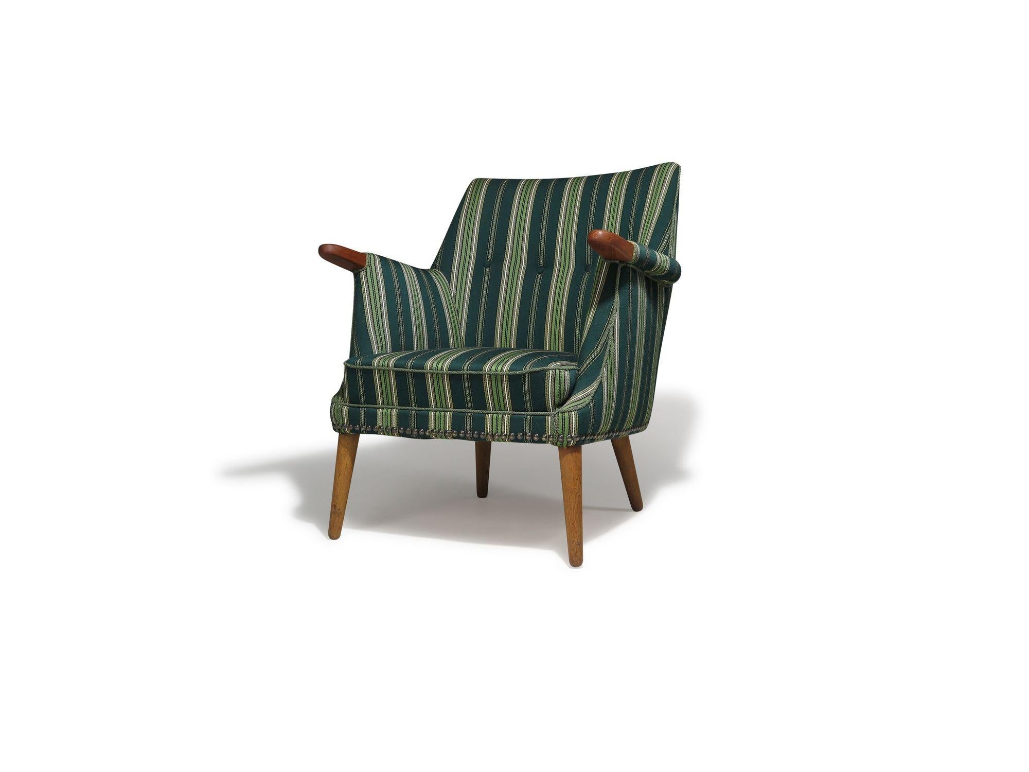 Si tratta di una sedia lounge danese della metà del secolo scorso, caratterizzata da linee pulite, forme organiche e design funzionale. Presenta una struttura in legno massiccio con gambe affusolate e una seduta con molle interne legate a mano,