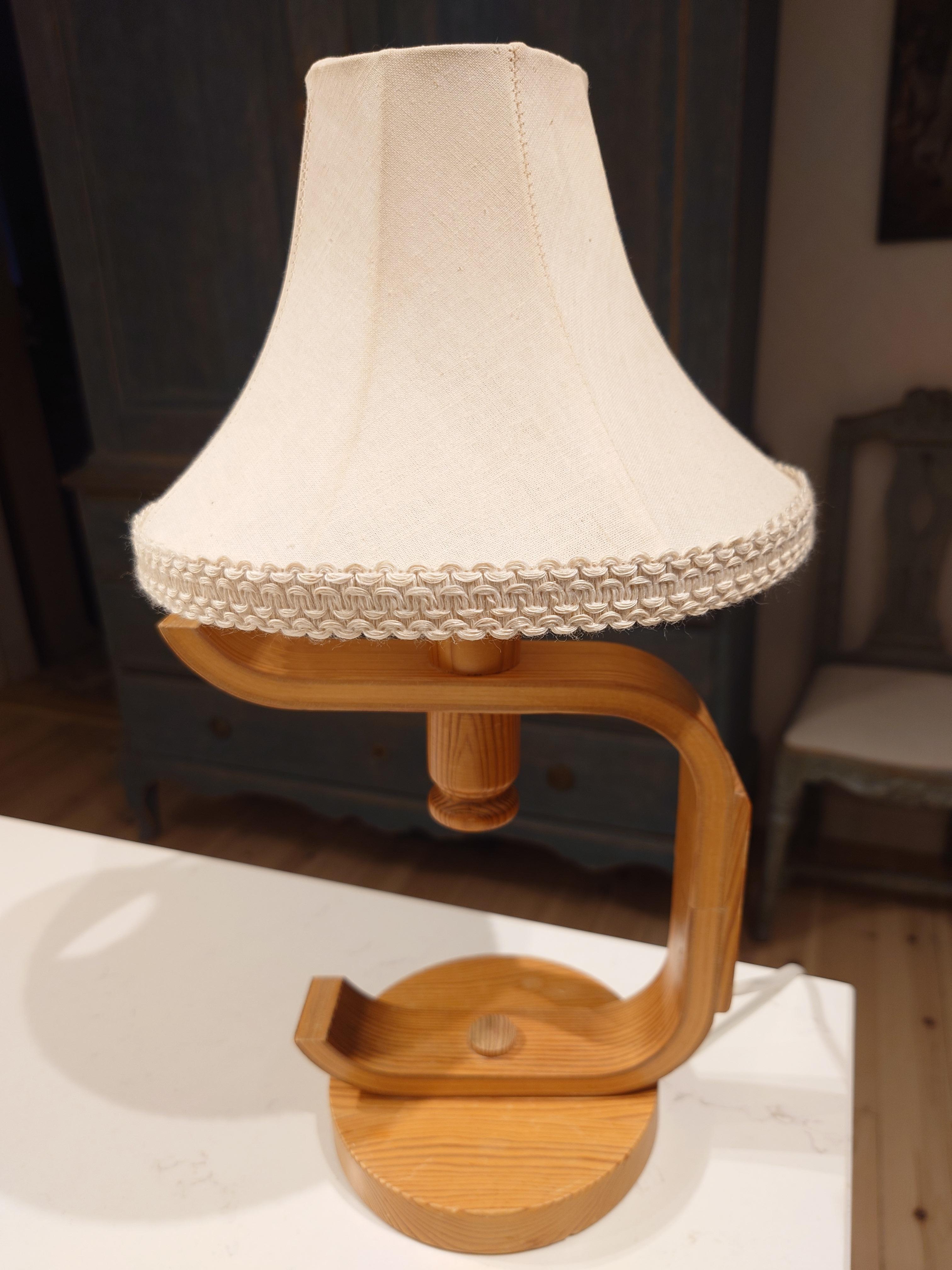 La lámpara de mesa de pino de aspecto agradable. La forma y el modo escultural en que está montada esta lámpara le dan un aspecto bonito y moderno. Buen estado de funcionamiento de época, con el desgaste propio de la edad y el uso.
 Dimensiones: