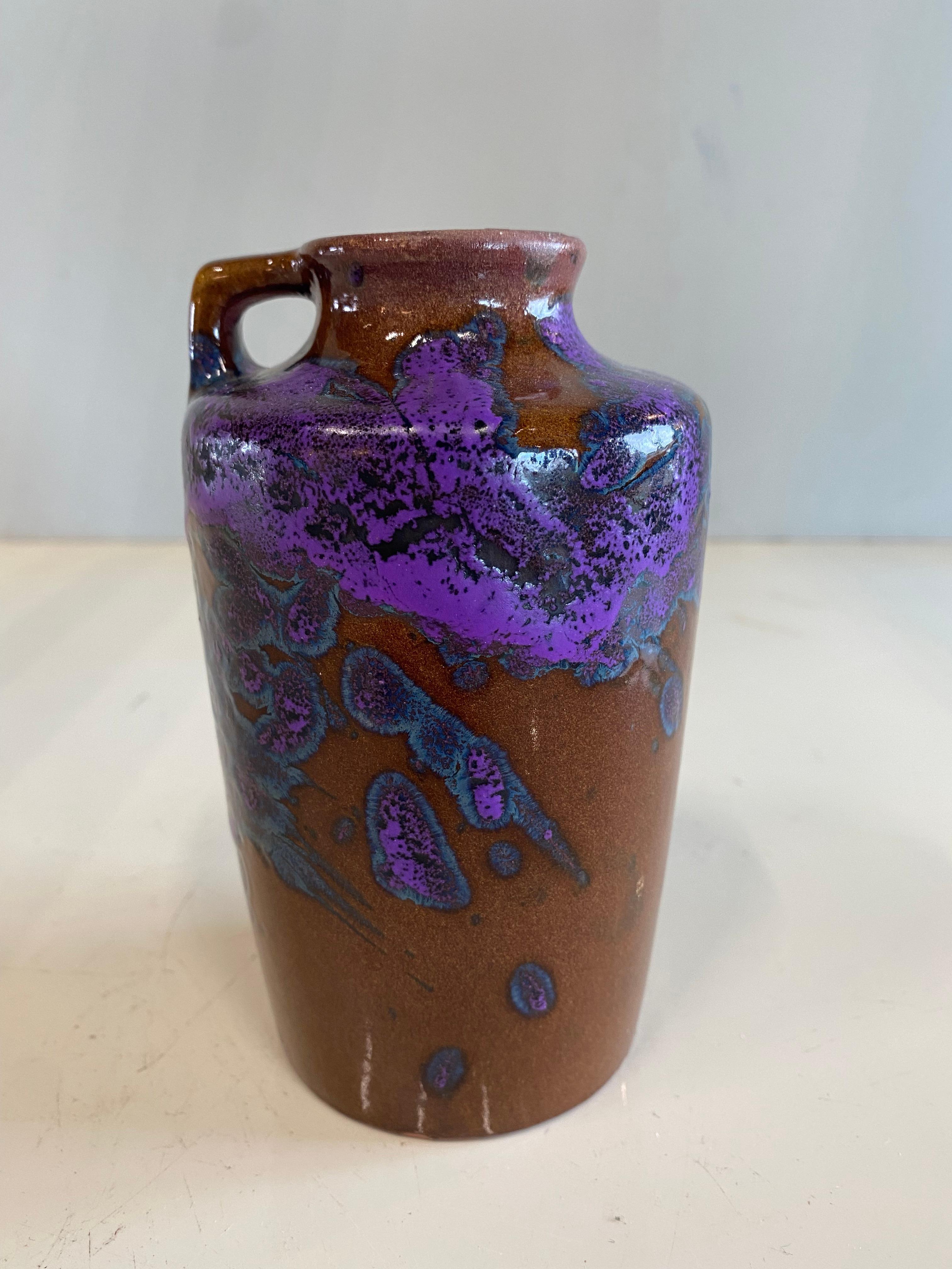 This small ceramic vase by Scheurrich could also be an Art Nouveau piece in terms of shape and colour. Nevertheless it is a mid century piece. 
The color speckles look less like ink blobs in water. The play of colors between the strong purple and