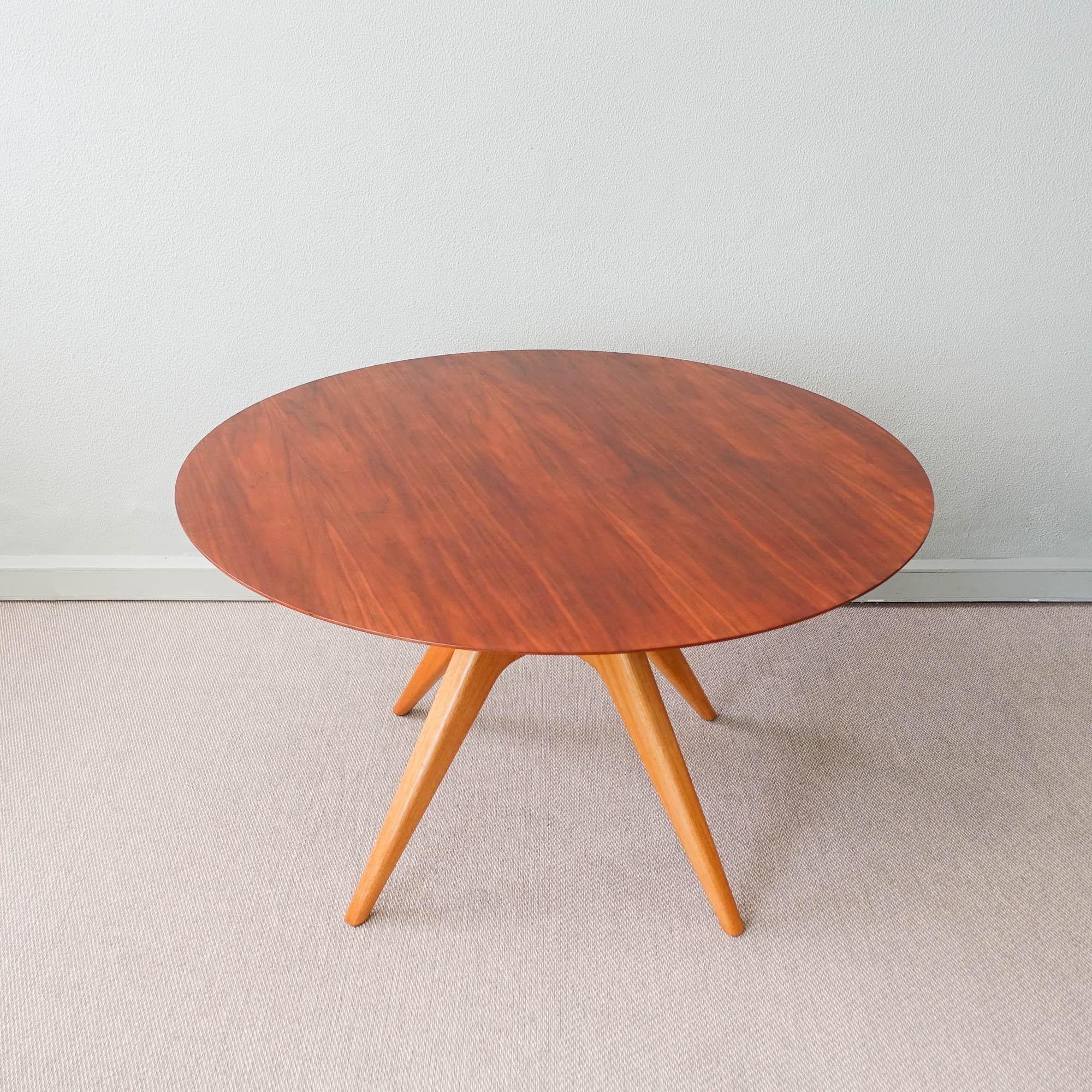 This dining table was designed and produced by Schuster, in Brazil, during the 1950's. It features a solid oak central feet where the table top in exotic wood is set through a screw. It was completely restored.