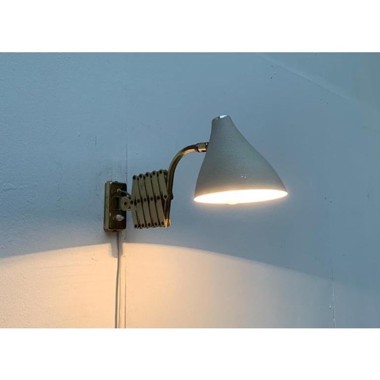 Applique da parete del Mid Century con braccio flessibile a forbice.

Colpisce il braccio a forbice finemente realizzato, che può espandere e regolare la portata e la posizione del Luminaire. In contrasto con il braccio color ottone