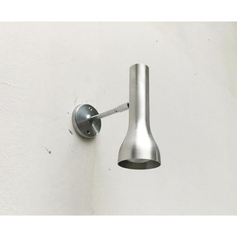 Minimalist wall lights from swisslamps.

a very simple and restrained design in aluminum and chrome. The lamp head shows a slim spotlight shape. It can be individually aligned via an omi joint and rotated on the wall plate. Thus it can be moved in