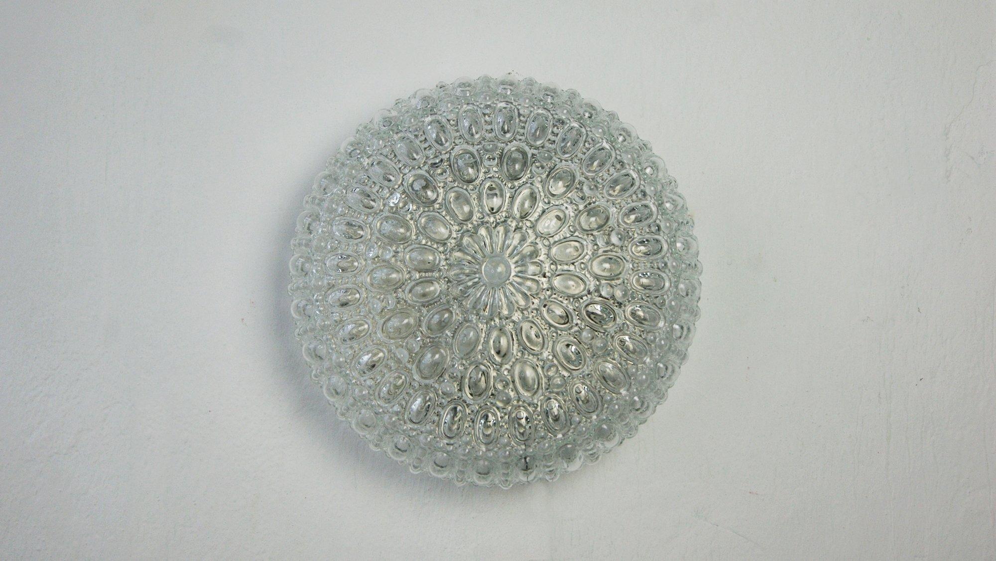 Il plafond risale agli anni '60 ed è stato prodotto da Glashütte Limburg. Il paralume è realizzato in vetro spesso e trasparente.
La superficie del paralume è composta da innumerevoli punte e forme geometriche. Il risultato di questa finitura