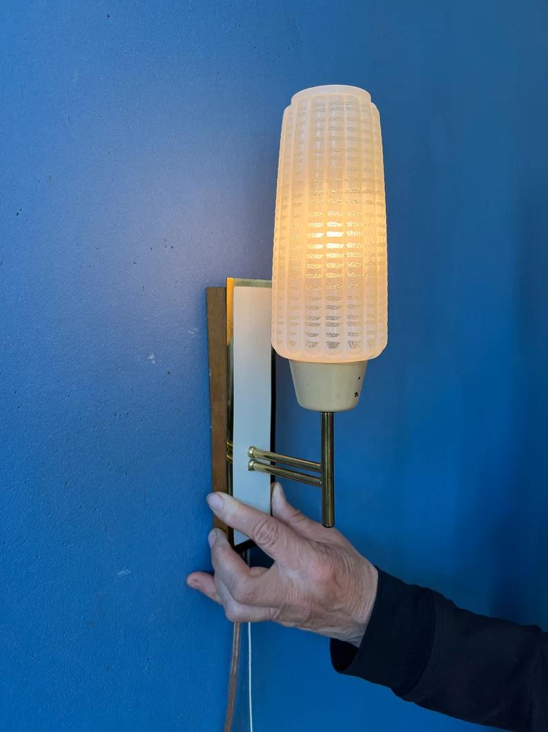 Vintage scandinavian style wall light with glass shade. The lamp is made out metal, glass and wood. The lamp requires one E27 lightbulb and currently has an EU-plug.

Additional information:
Materials: Metal, plastic
Period: 1970s
Dimensions: ø: 7
