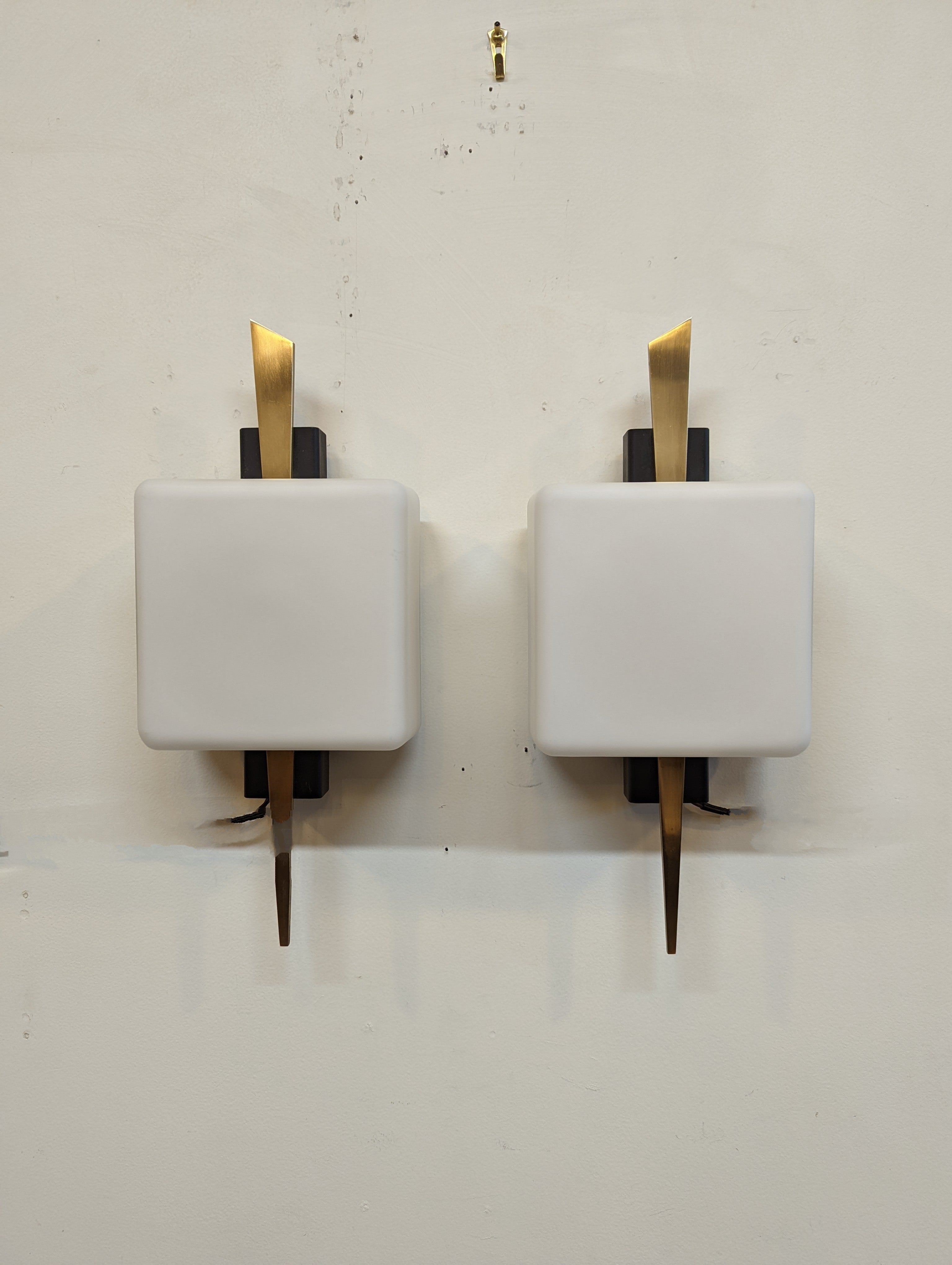 Magnificent pair of Arlus sconces. French Mid Century Modern Sconces by Maison Arlus. Solid brass arrows pointing down through cubed white frosted glass diffusers set an impressive light source for any wall. Luminating a warm light glowing in a