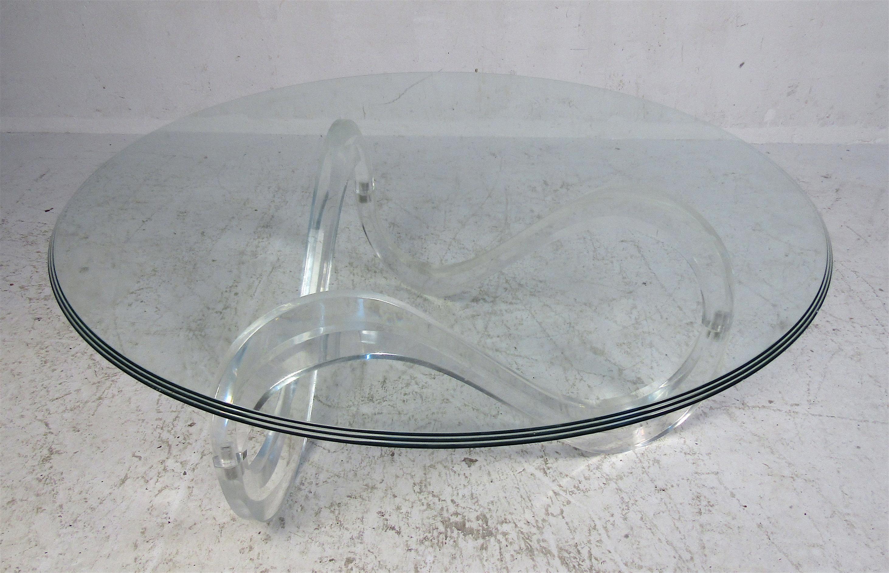 This stunning vintage modern coffee table features an unusual Lucite base with a thick round glass top. A sleek design with sculpted Lucite and circular glass with graduating edges. This stylish coffee table is sure to complement any home, business,