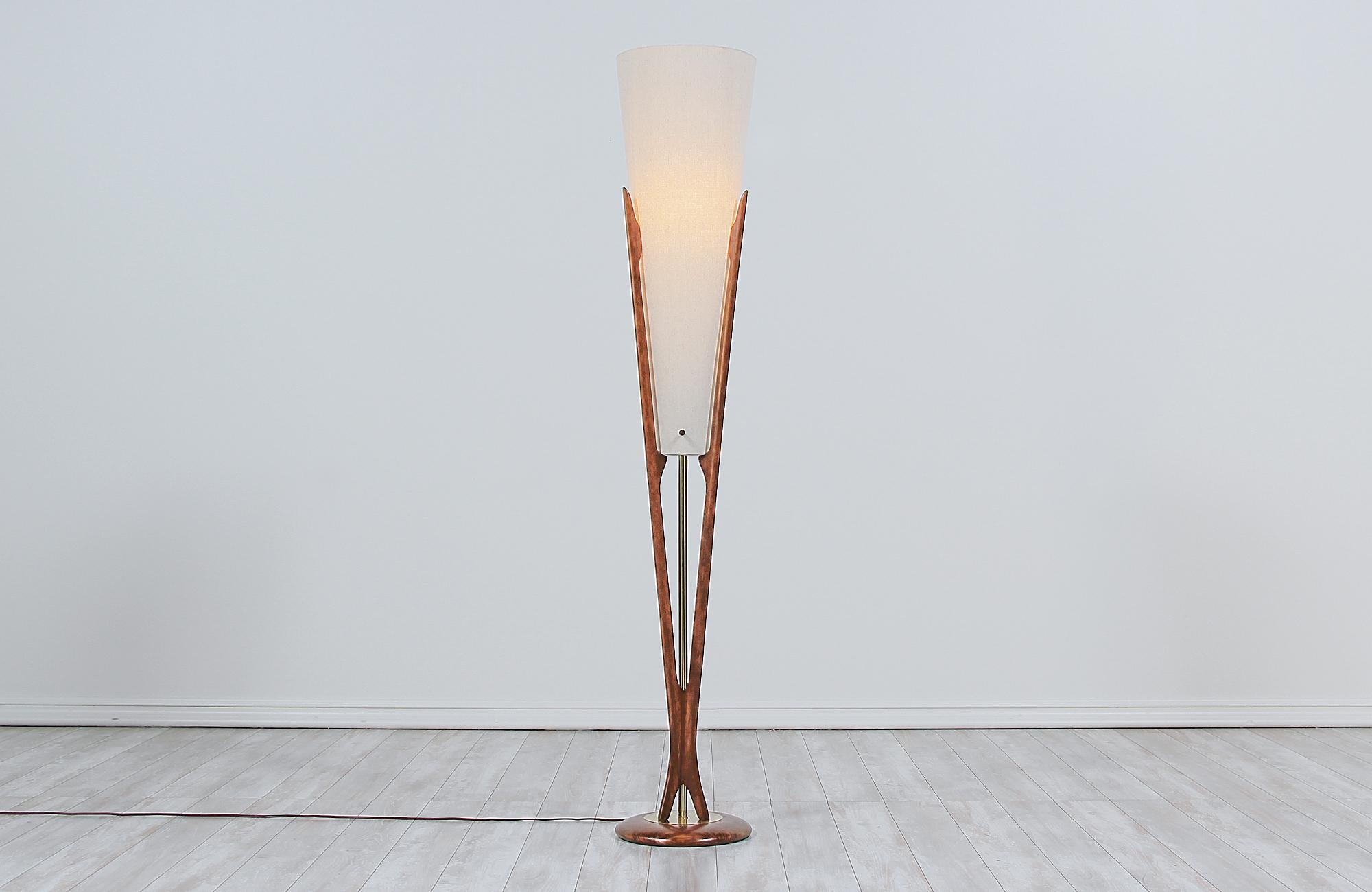 Stunning sculpted modern floor lamp designed and manufactured by Modeline of California in the United States, circa 1960s. This rare floor lamp is comprised of a carved walnut wood frame that connects from the top to the rounded base creating a ‘V’
