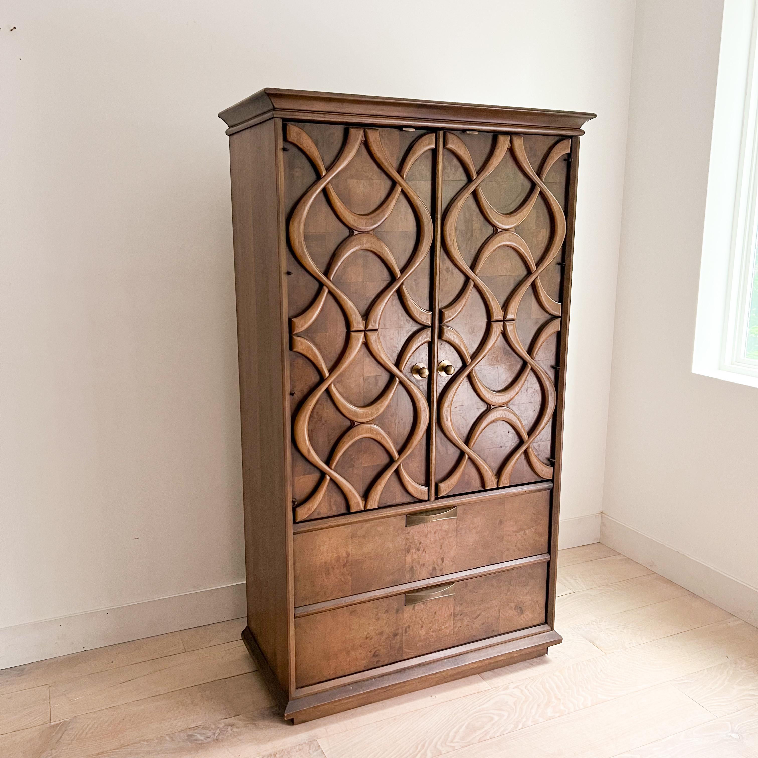 This sophisticated tall wardrobe from Stanley’s esteemed “Cosmopolitan” line showcases the striking sculpted front characteristic of mid-century modern design. Inside the cabinet door, a mirror adds functionality and elegance.

Dimensions: 39.5” L x